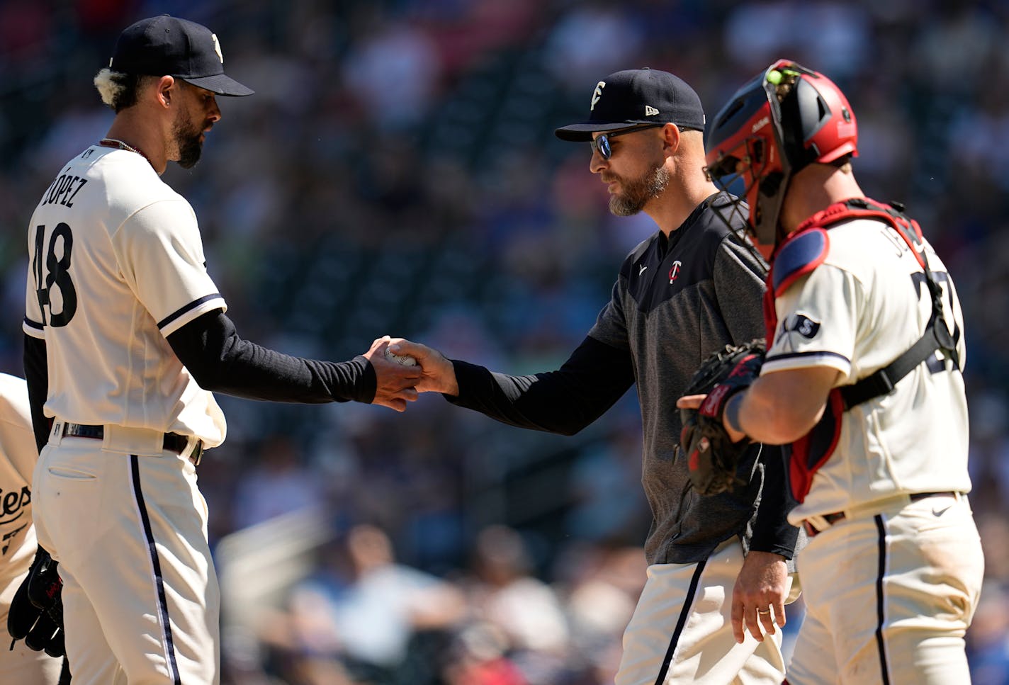 Minnesota Twins manager Rocco Baldelli, center, takes the ball from relief pitcher Jorge Lopez, left, during the ninth inning of a baseball game against the Toronto Blue Jays, Saturday, May 27, 2023, in Minneapolis. (AP Photo/Abbie Parr)