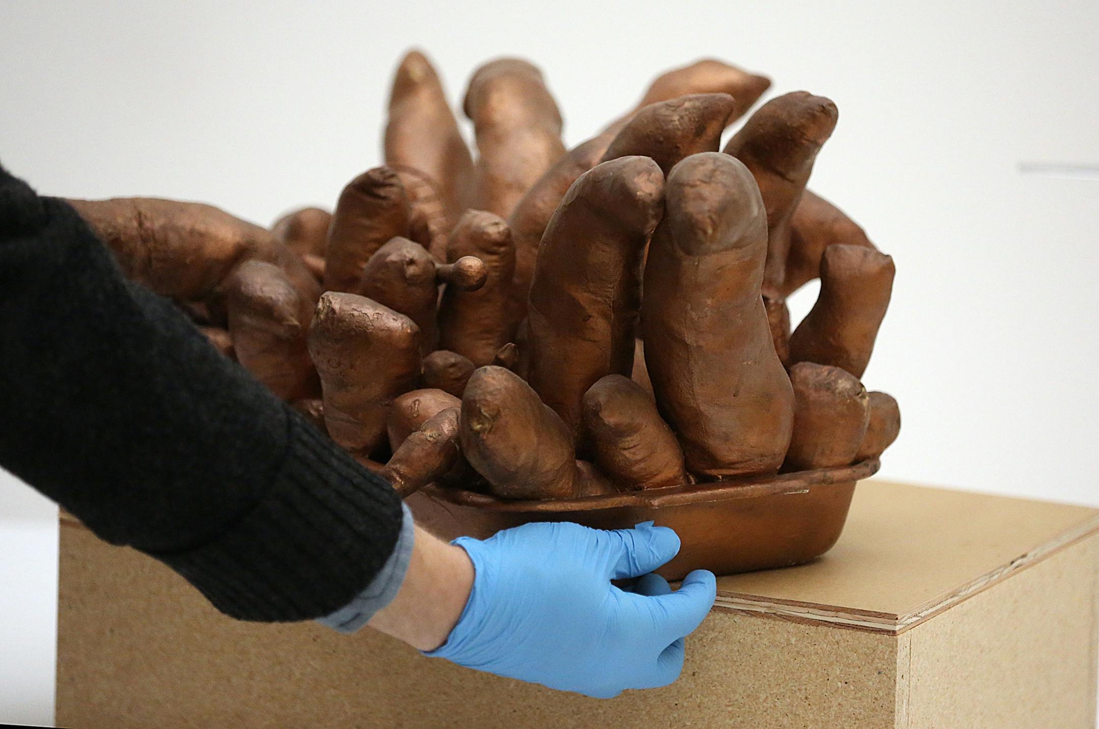 A piece entitled Oven-Pan (paint, canvas, cotton, steel, wood) by Yayoi Kusama, Japanese, born 1929, is moved into place.