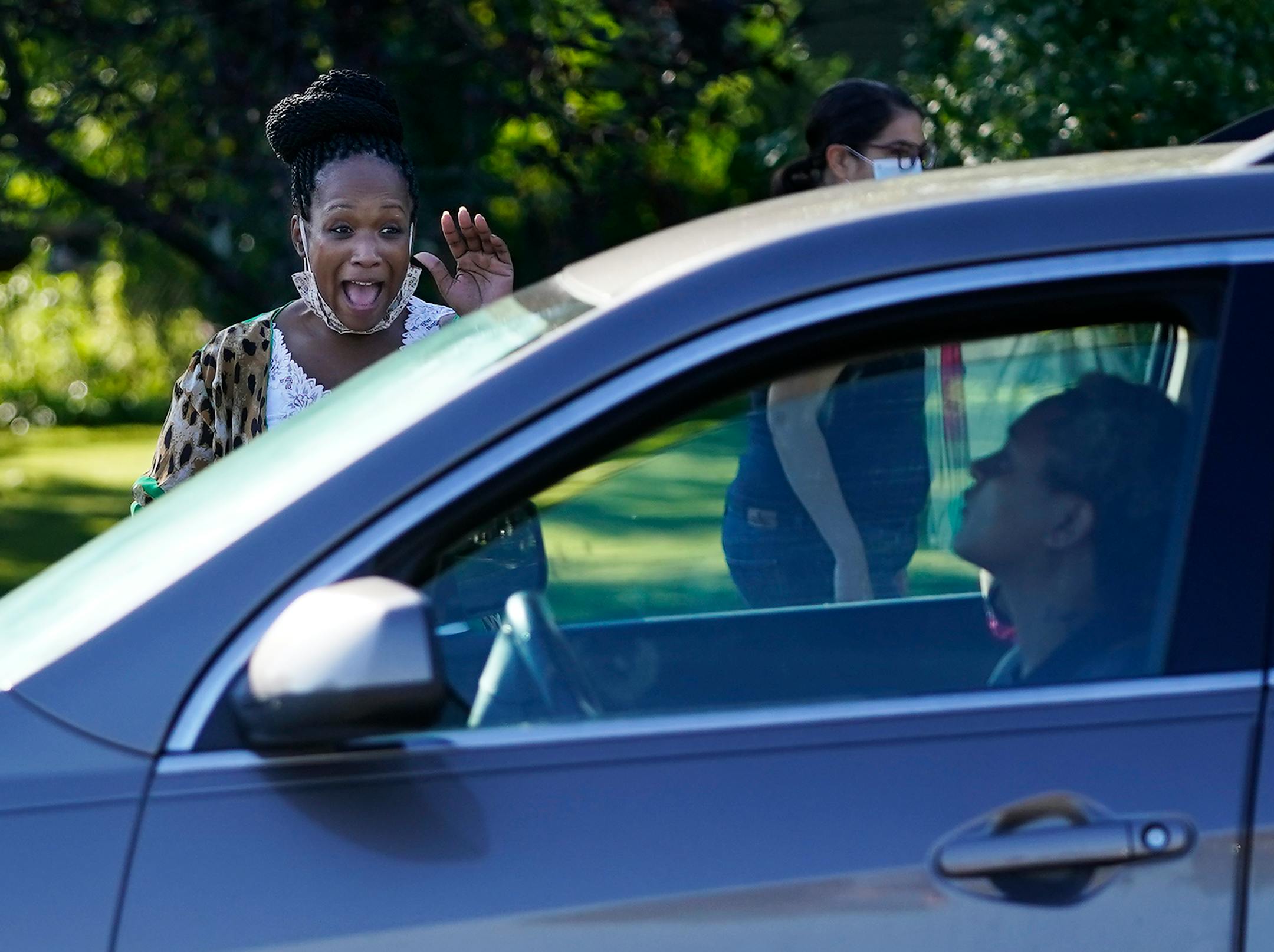 New Hoover Elementary School principal Keisha Davis waved at an arriving student and parent while directing traffic in the parking lot before the start of the first day of school Tuesday in Coon Rapids.   ]