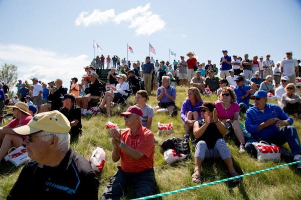 People applaud for the first round of the 3M Golf Tournament at hole one, in Blaine.
