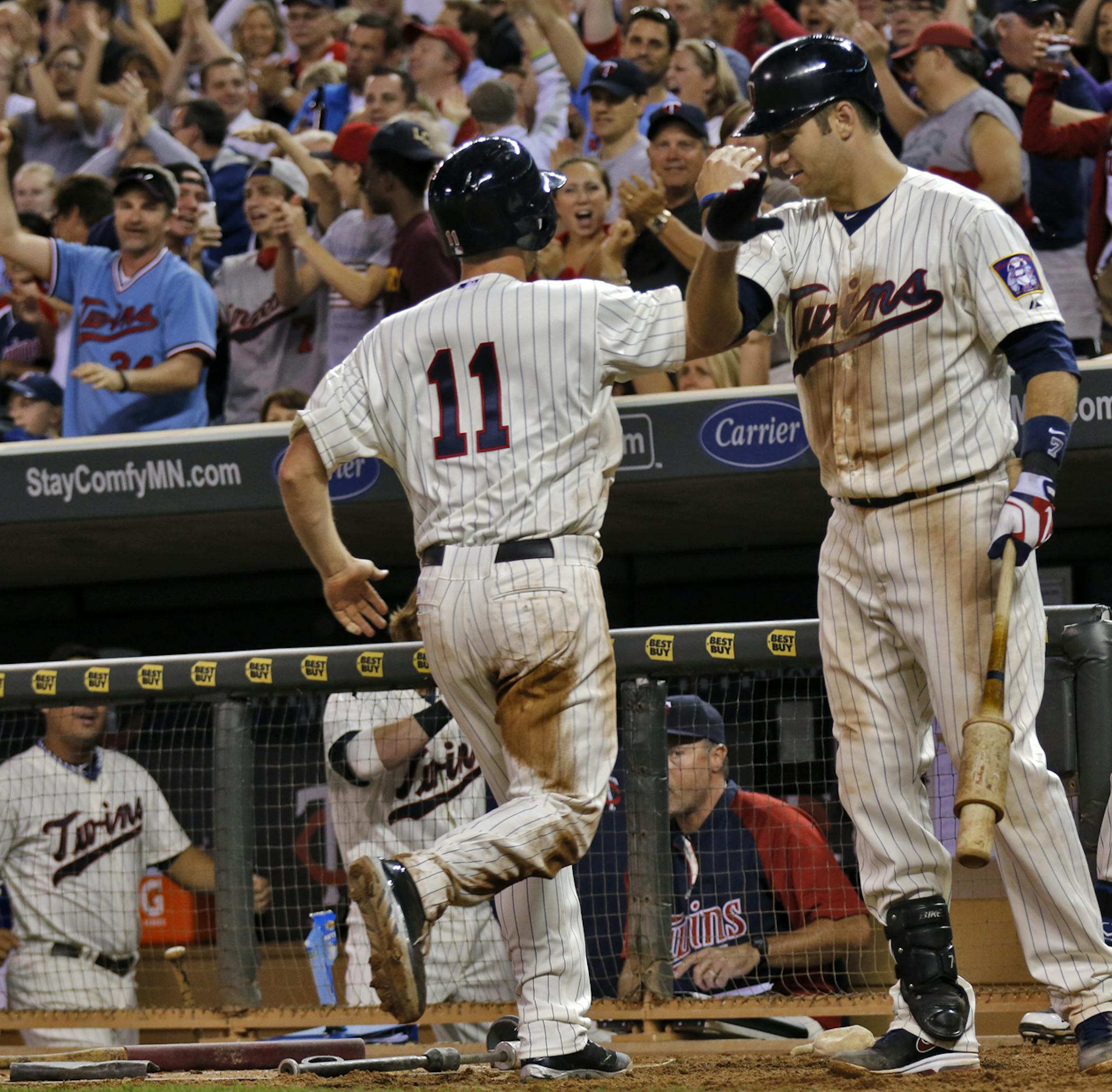 Minnesota Twins vs. Philadelphia Phillies. Twins win 4-3. Twins Clete Thomas (11) was congratulated by teammates and fans after he scored the winning run in 8th inning action. (MARLIN LEVISON/STARTRIBUNE(mlevison@startribune.com (cq program )