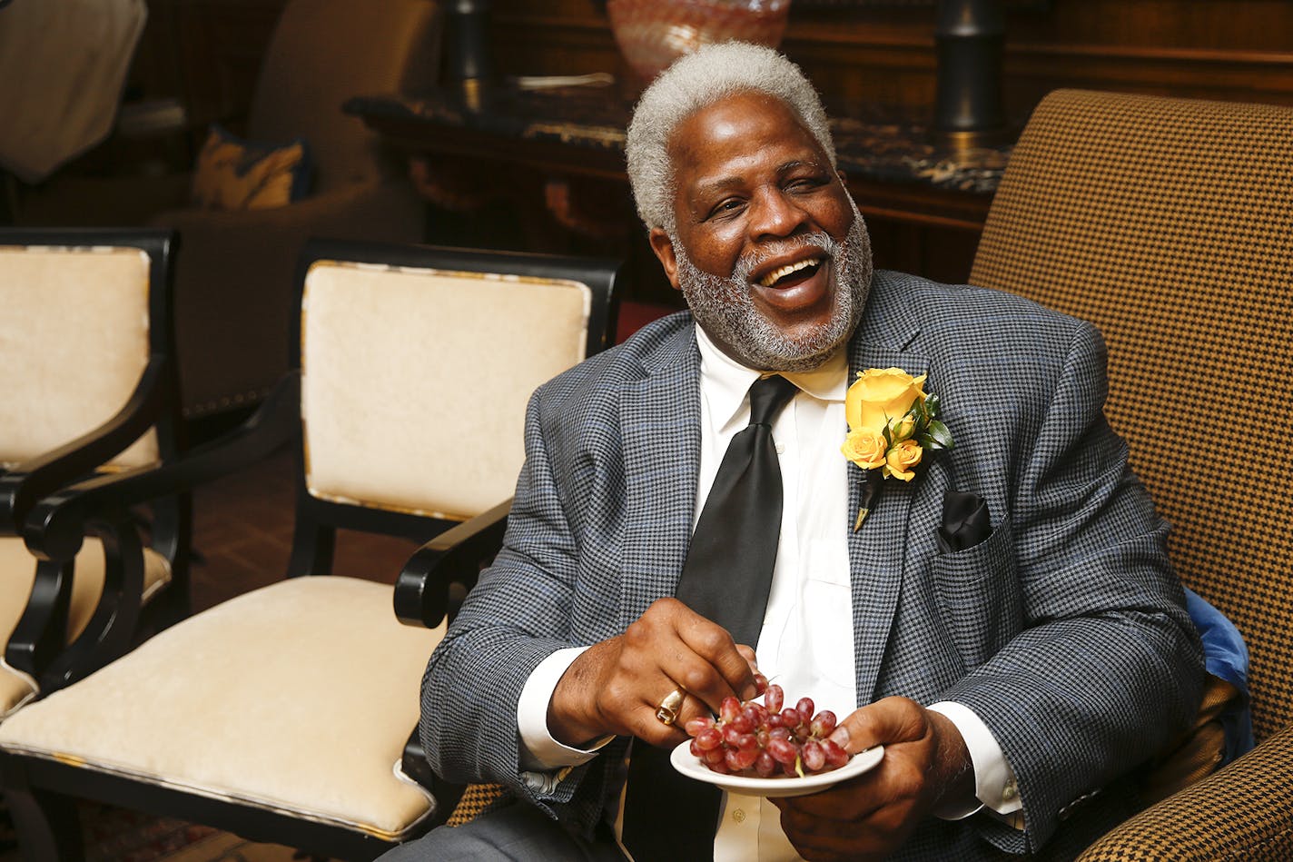 In this Wednesday, Jan. 10, 2018 photo, Hall of Fame football player Earl Campbell smiles as he eats grapes a friend brought him during the Fifth Annual Earl Campbell Tyler Rose Award Banquet at the Willow Brook Country Club in Tyler, Texas. Oklahoma quarterback Baker Mayfield won the award. (Chelsea Purgahn