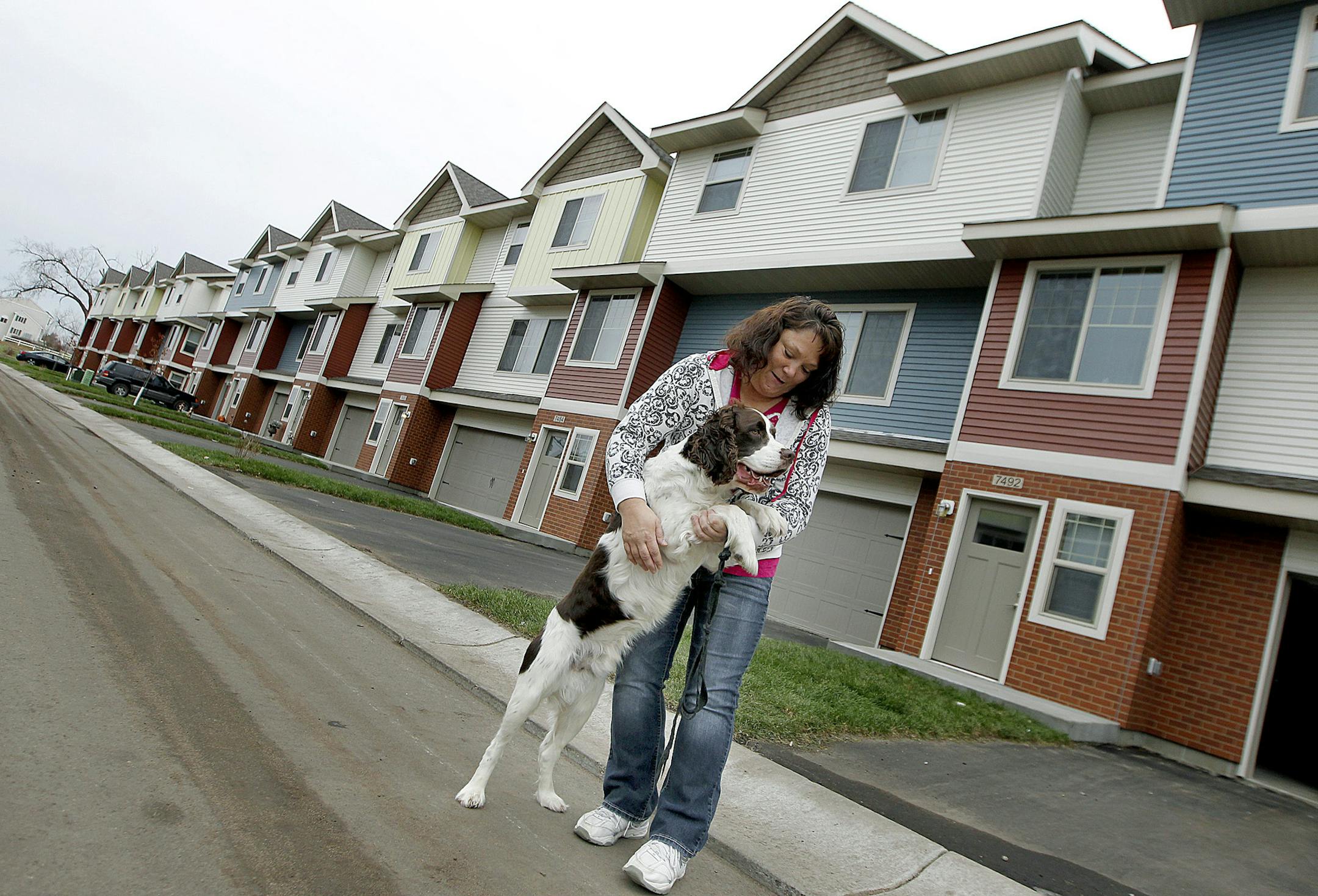 Kris Thuhl played with her dog "Max" outside the new home she just moved her family into, Thursday, November 14, 2013 in Ramsey, MN. UnitedHealth is investing $50 million in Minnesota to build affordable housing units. Their home, is in the Seasons Townhomes, a 50-unit complex in Ramsey that is part of a $100 million nationwide investment. (ELIZABETH FLORES/STAR TRIBUNE) ELIZABETH FLORES • eflores@startribune.com