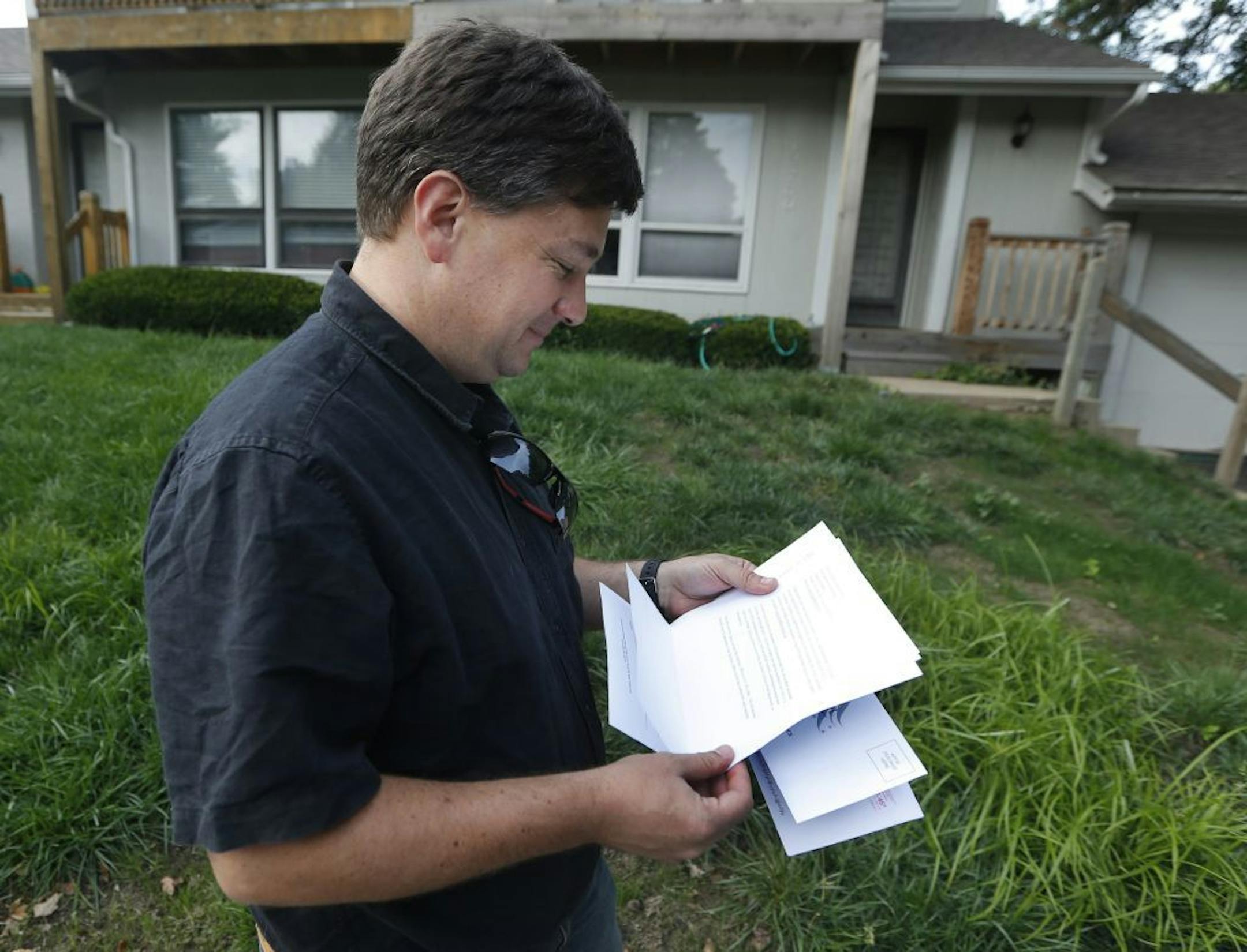 Aaron Belenky reads a letter from election officials while standing in front of his apartment in Overland Park, Kan., Wednesday, Aug. 14, 2013.