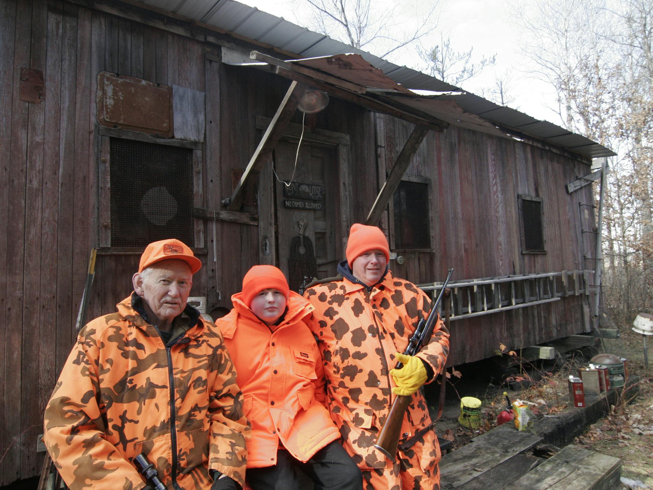 Rick Storck, 76, of Greenfield (left) has been hunting deer from his wooden railroad car hunting shack for nearly 50 years, outliving two of his old hunting buddies. Among those hunting with him on Saturday's deer opener this year was son-in-law George Meyer, 41, (right), and grandson Vincent Meyer, 11, of New Prague. Photo by Doug Smith/Star Tribune.