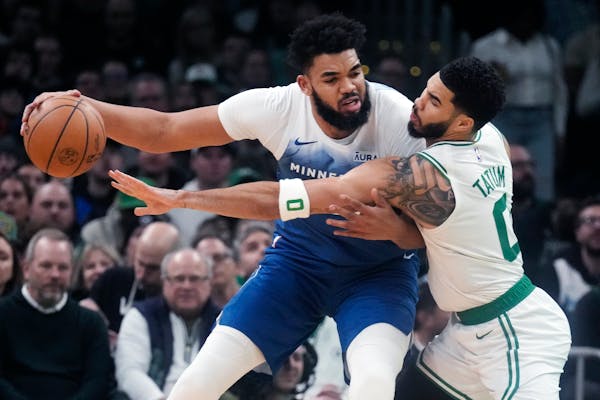 Timberwolves center Karl-Anthony Towns, who had 25 points and 13 rebounds, battled Celtics forward Jayson Tatum in the post Wednesday night in Boston.