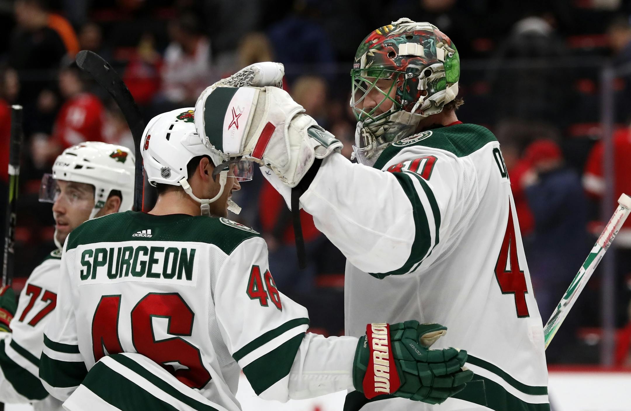 Minnesota Wild goaltender Devan Dubnyk is greeted by defenseman Jared Spurgeon (46) after the Wild's 3-2 win over the Detroit Red Wings in an NHL hockey game Friday, Feb. 22, 2019, in Detroit. (AP Photo/Carlos Osorio)