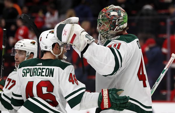 Minnesota Wild goaltender Devan Dubnyk is greeted by defenseman Jared Spurgeon (46) after the Wild's 3-2 win over the Detroit Red Wings in an NHL hock