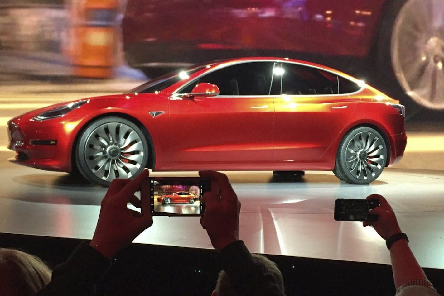 In this March 31, 2016, file photo, Tesla Motors unveils the new lower-priced Model 3 sedan at the Tesla Motors design studio in Hawthorne, Calif. Electric car maker Tesla said on Monday, July 3, 2017, that its Model 3 car will go on sale on Friday.