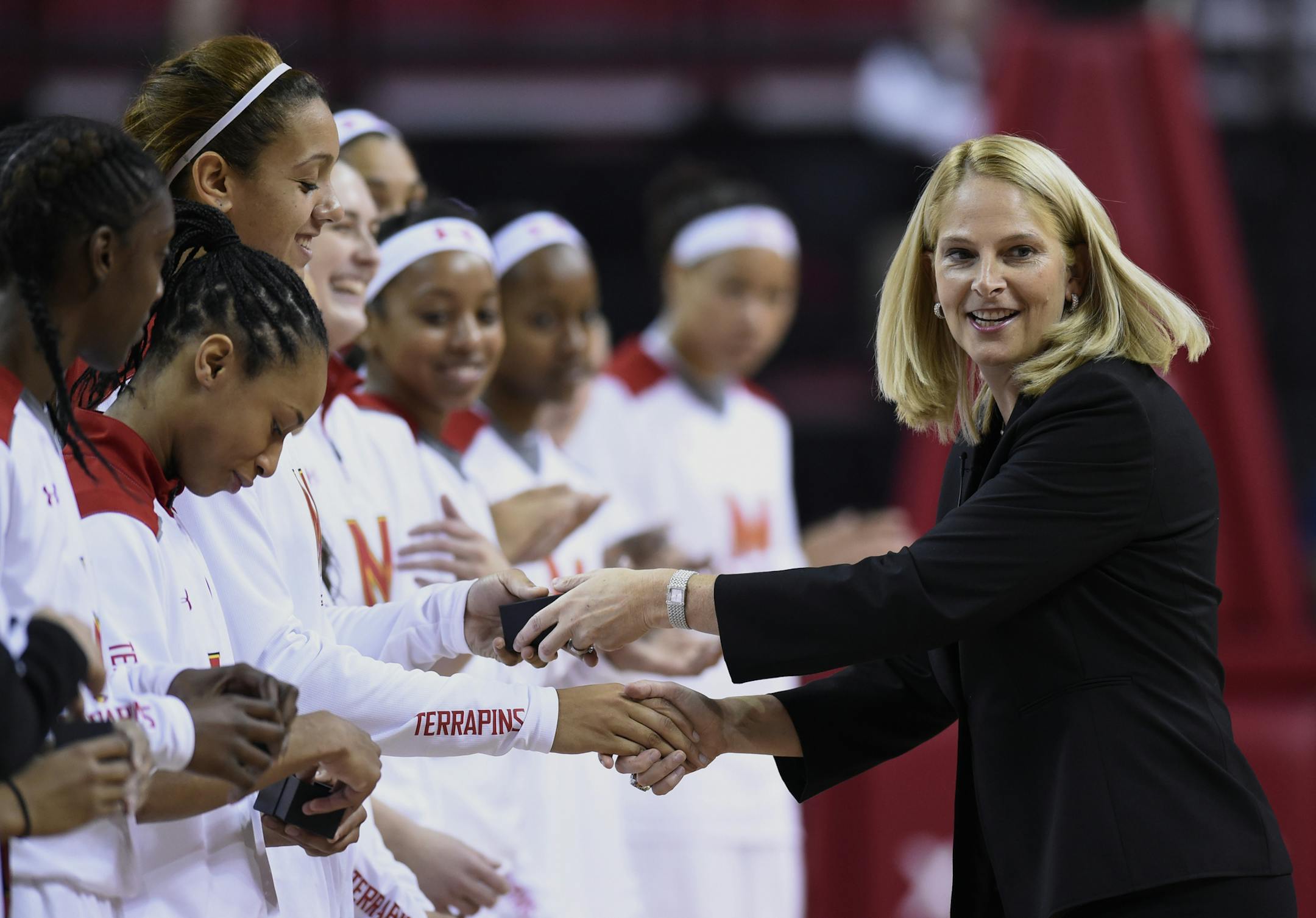Maryland women's basketball head coach Brenda Frese, right, hands out Final Four rings to members of the 2014 basketball team before playing Wagner in a NCAA college basketball game Sunday, Nov. 16, 2014 in College Park, Md.(AP Photo/Gail Burton) ORG XMIT: OTKS101 ORG XMIT: MIN1501091853431242