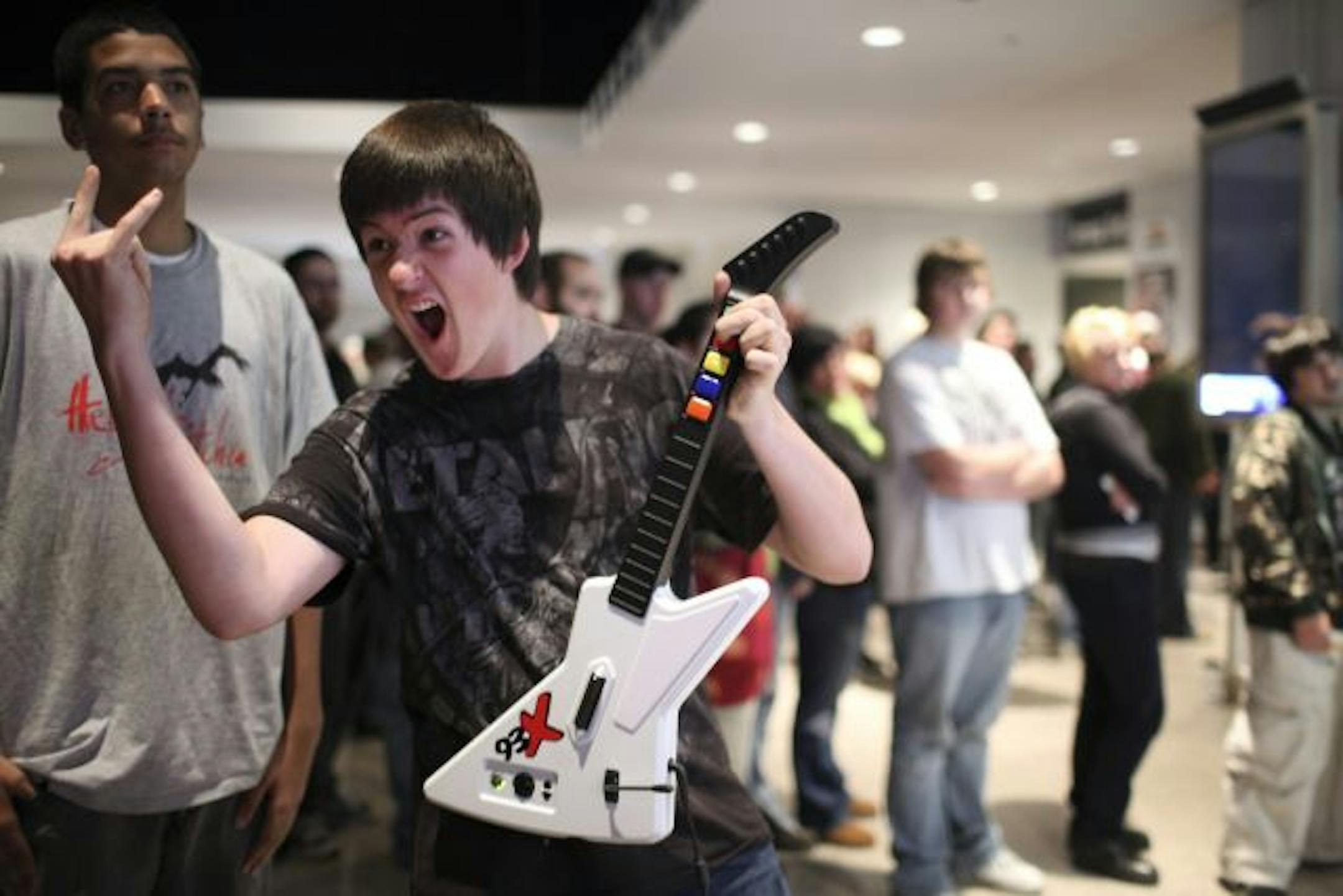 Bryson Watt of Maplewood struck a pose as he began to rock out on Guitar Hero: Metallica at a radio station's booth in the Target Center lobby Tuesday night. He and his buddy, Chris Cleary, left, were attending the Metallica show. He hit 89% of the notes on Dyer's Eve, the song he played on the video game.