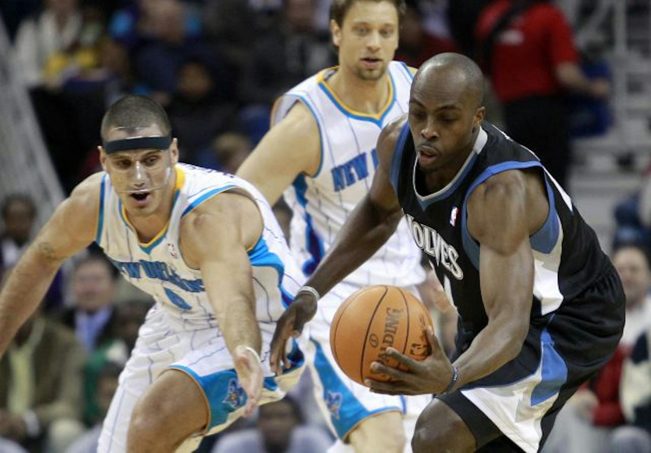 New Orleans Hornets forward Sasha Pavlovic, left, watches as Minnesota Timberwolves center Anthony Tolliver gets his hand on a loose ball during the first quarter of an NBA basketball game in New Orleans, Monday, Feb. 7, 2011.