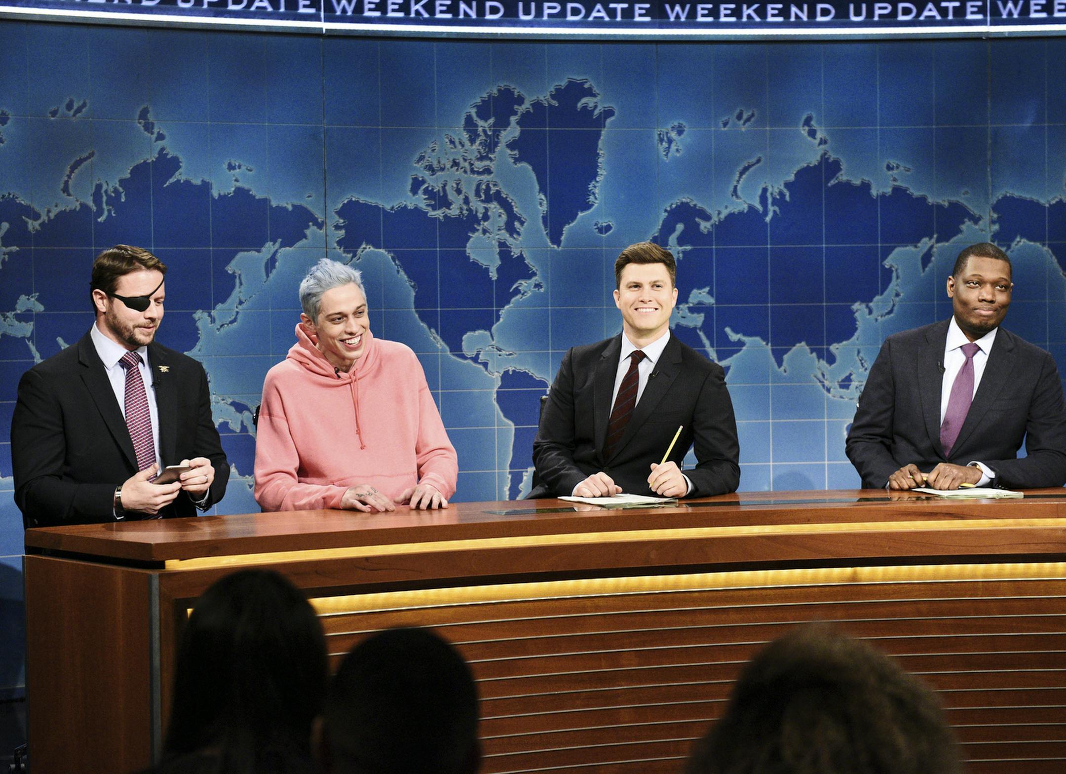 In this Nov. 10, 2018 photo provided by NBC, Lt. Com. Dan Crenshaw, from left, a congressman-elect from Texas, Pete Davidson, Anchor Colin Jost, and Anchor Michael Che appear during Saturday Night Live’s "Weekend Update" in New York. Davidson made his apologies to Crenshaw whose appearance he mocked, saying Crenshaw “deserves all the respect in the world.” (Will Heath/NBC via AP)