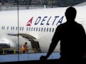 A passenger looks out towards a Delta Air Lines Inc. plane at San Francisco International Airport in San Francisco.
