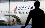 A passenger looks out towards a Delta Air Lines Inc. plane at San Francisco International Airport in San Francisco.