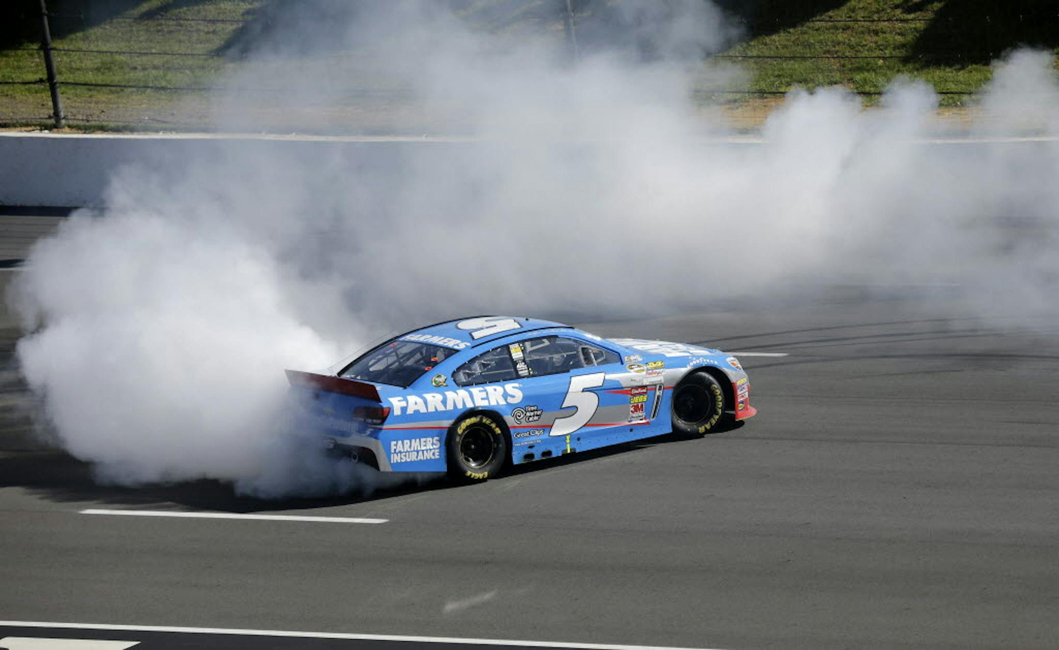 Kasey Kahne (5) does a burn out after winning a NASCAR Sprint Cup Series auto race Sunday at Pocono Raceway.