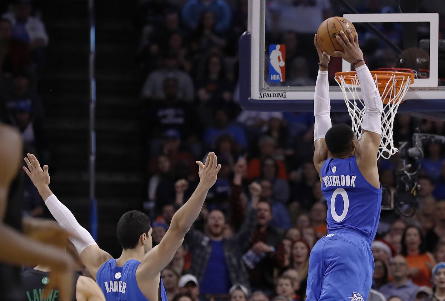 Oklahoma City Thunder guard Russell Westbrook, right, goes up for a dunk against the Minnesota Timberwolves as Oklahoma City Thunder center Enes Kanter, left, reacts during the first half of an NBA basketball game in Oklahoma City, Sunday, Dec. 25, 2016. (AP Photo/Alonzo Adams)