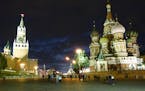 Moscow lights up at night with St. Basil&#x2019;s Cathedral, right, and the Kremlin clock tower, left.