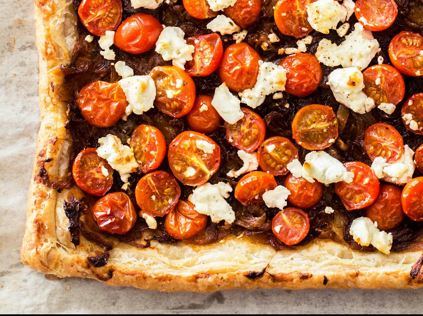 Caramelized onions, goat cheese and tomatoes combine to make a tart that's delicious served warm or at room temperature. Credit: Carl Tremblay. From "The Savory Baker" by America's Test Kitchen (2022).