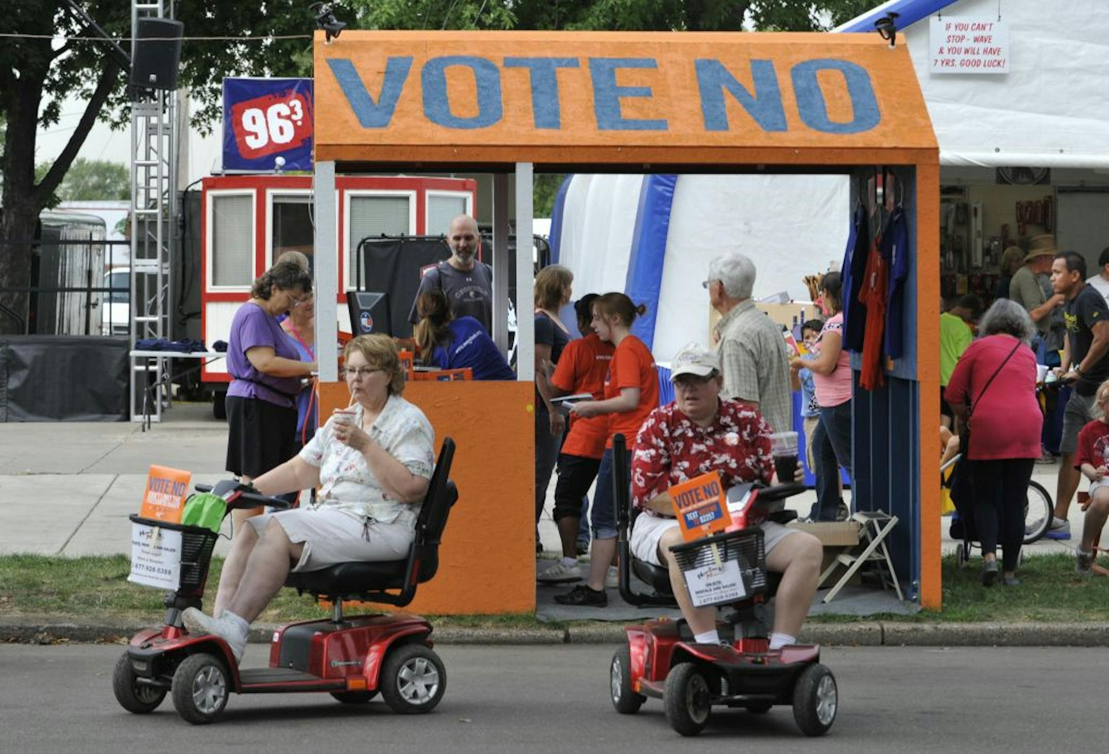 Visitors on motorized scooters with vote no signs attached leave a Minnesota State Fair booth calling for a no vote on the Minnesota amendment banning gay marriage Thursday, Aug. 23, 2012 in Falcon Heights, Minn., as both sides of the issue made their case to fair goers.