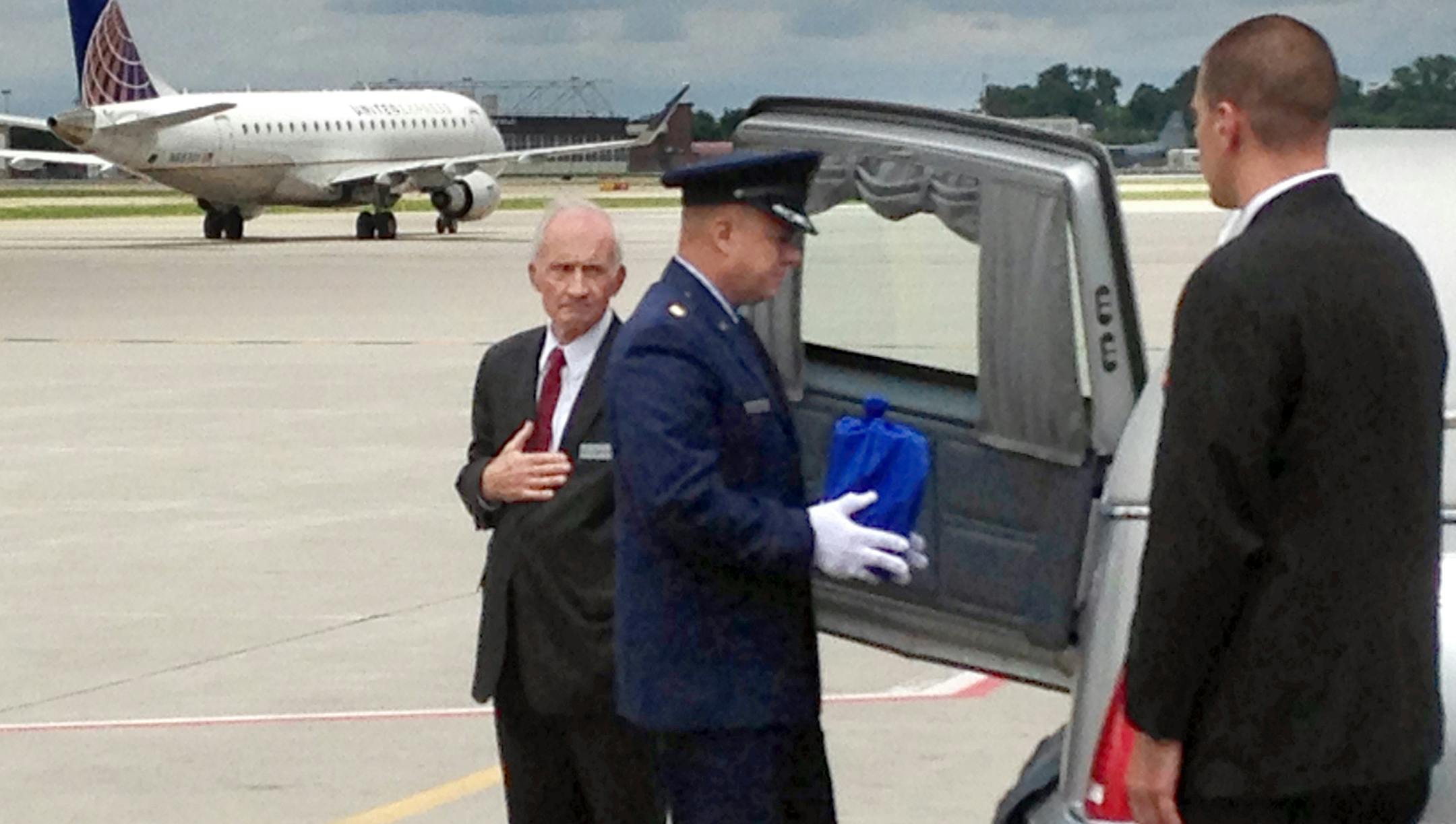 Air Force Maj. Melvin Smith placed an urn carrying the remains of fellow airman Maj. Robert Olson of St. Paul in a hearse at Minneapolis-St. Paul International Airport.