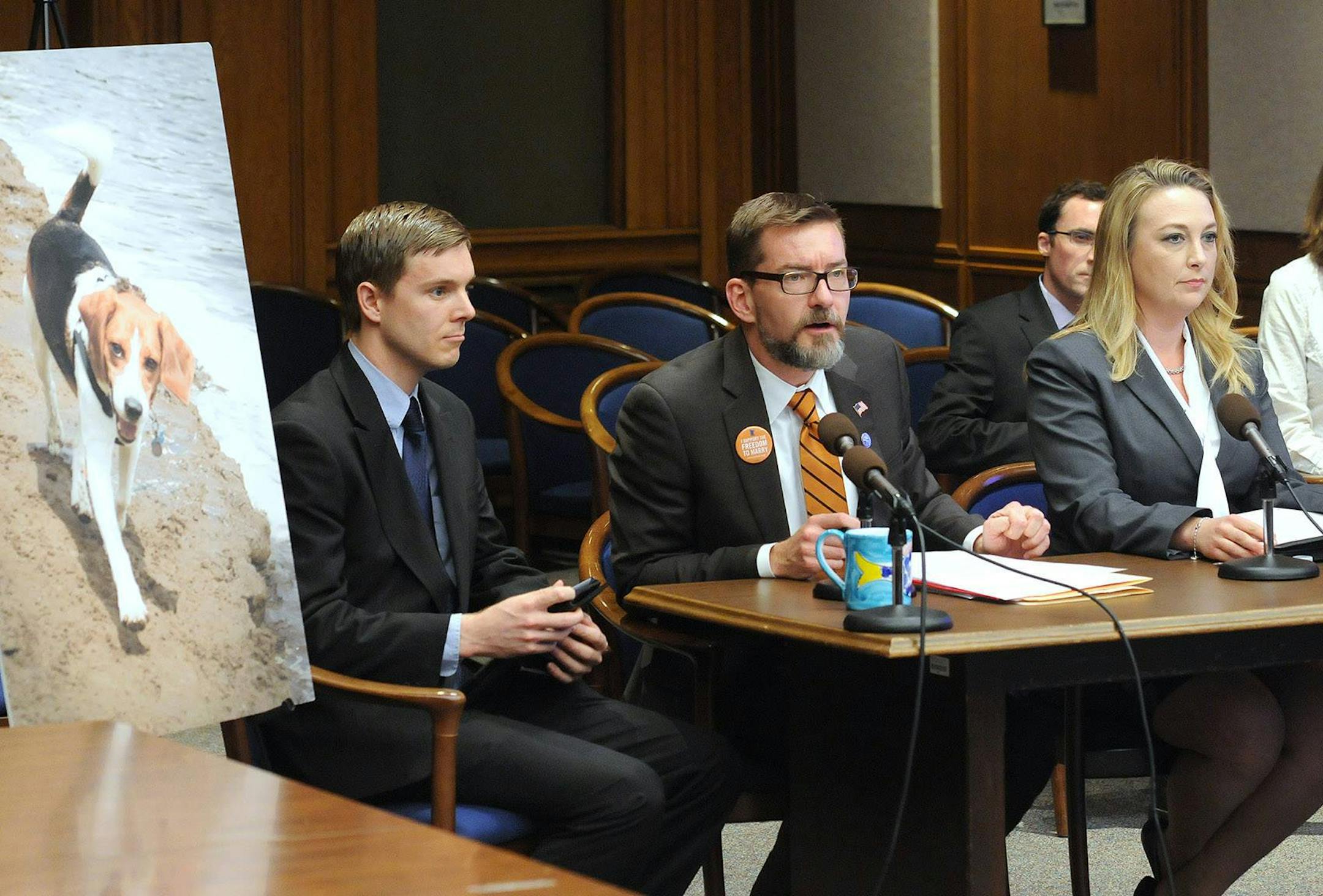 Sen. Scott Dibble, DFL-Minneapolis, speaks before the Senate Higher Education Committee in 2013 in favor of a bill making laboratory animals available for adoption. To the right is Shannon Keith, president of the Beagle Freedom Project, and to the left is Aaron Zellhoefer, who adopted the former research dog pictured. ORG XMIT: MIN1505081241331318