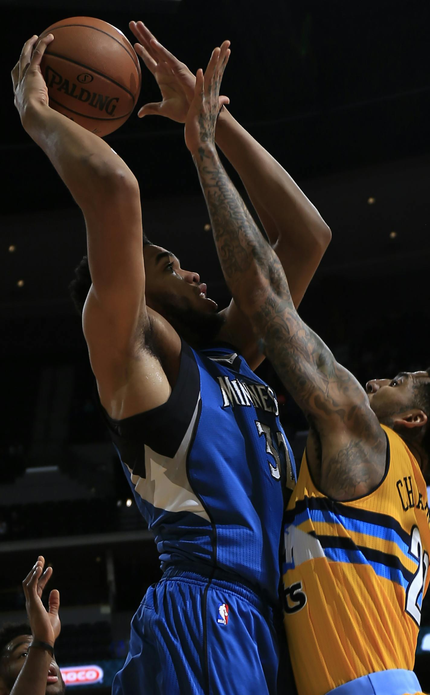 Denver Nuggets forward Wilson Chandler (21) tries to block Minnesota Timberwolves center Karl-Anthony Towns (32) during the first half of an NBA basketball game Wednesday, Dec. 28, 2016, in Denver. (AP Photo/Jack Dempsey)