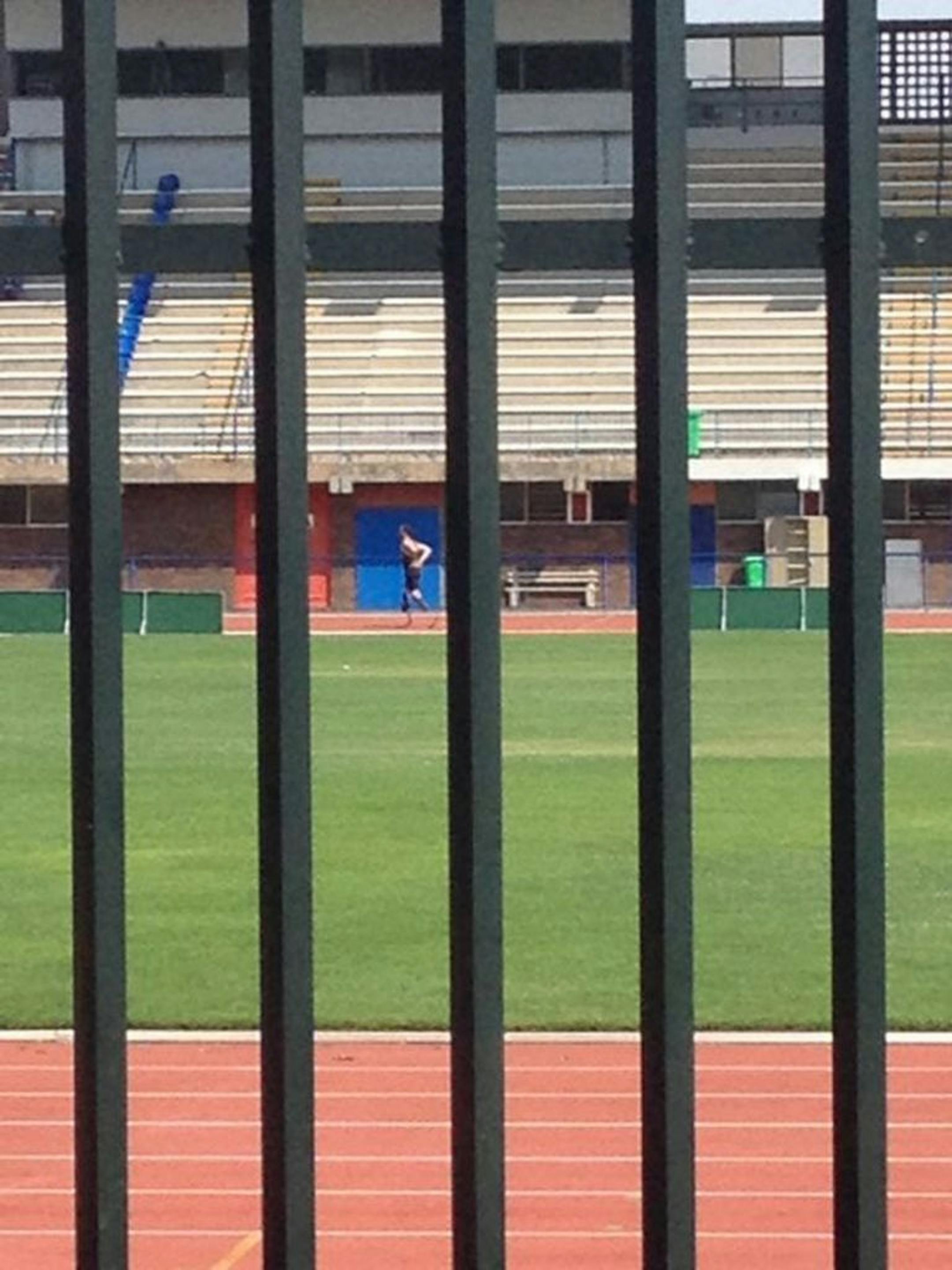 In this photo taken March 24 2013, shows Olympian athlete Oscar Pistorius running on the track at the University of Pretoria South Africa. The photo was taken by a pupil from the Voortrekker High School in Pietermaritzburg while on a hockey tour in Pretoria. A South African newspaper published the grainy cellphone image of Pistorius at a running track in his carbon fiber blades Thursday as the Olympian�s agent said his return to training was now imminent, but denied he was already in training.