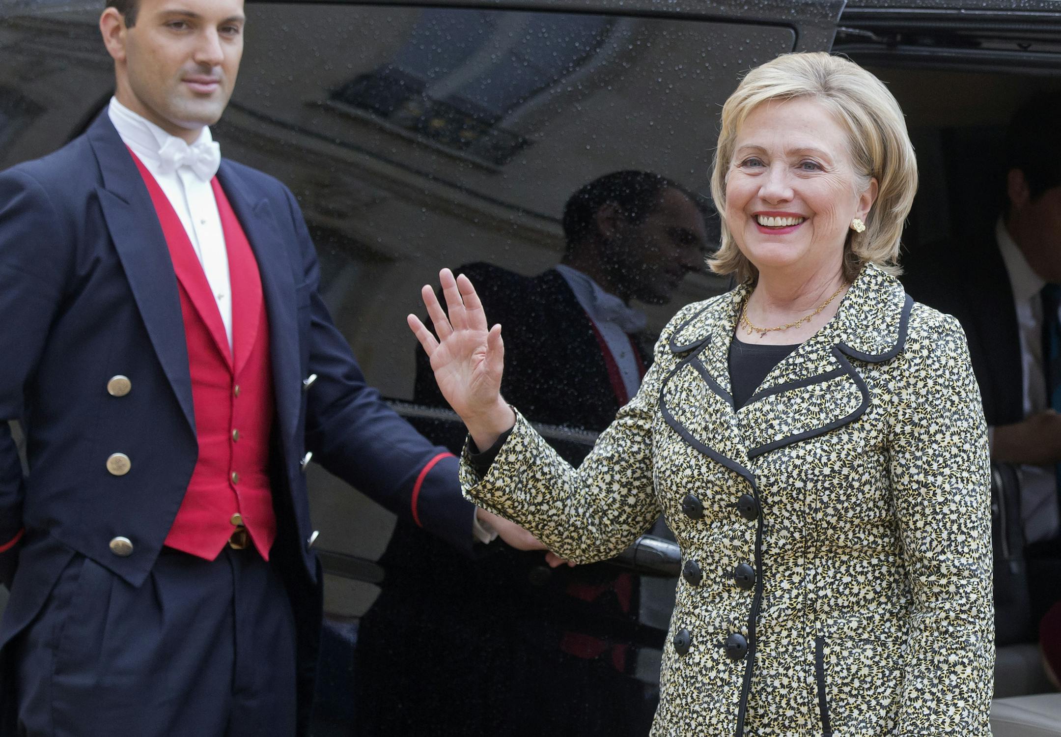 Former U.S. Secretary of State Hillary Rodham Clinton waves to the media after a meeting with French President Francois Hollande at the Elysee Palace in Paris, Tuesday, July 8, 2014. (AP Photo/Michel Euler)