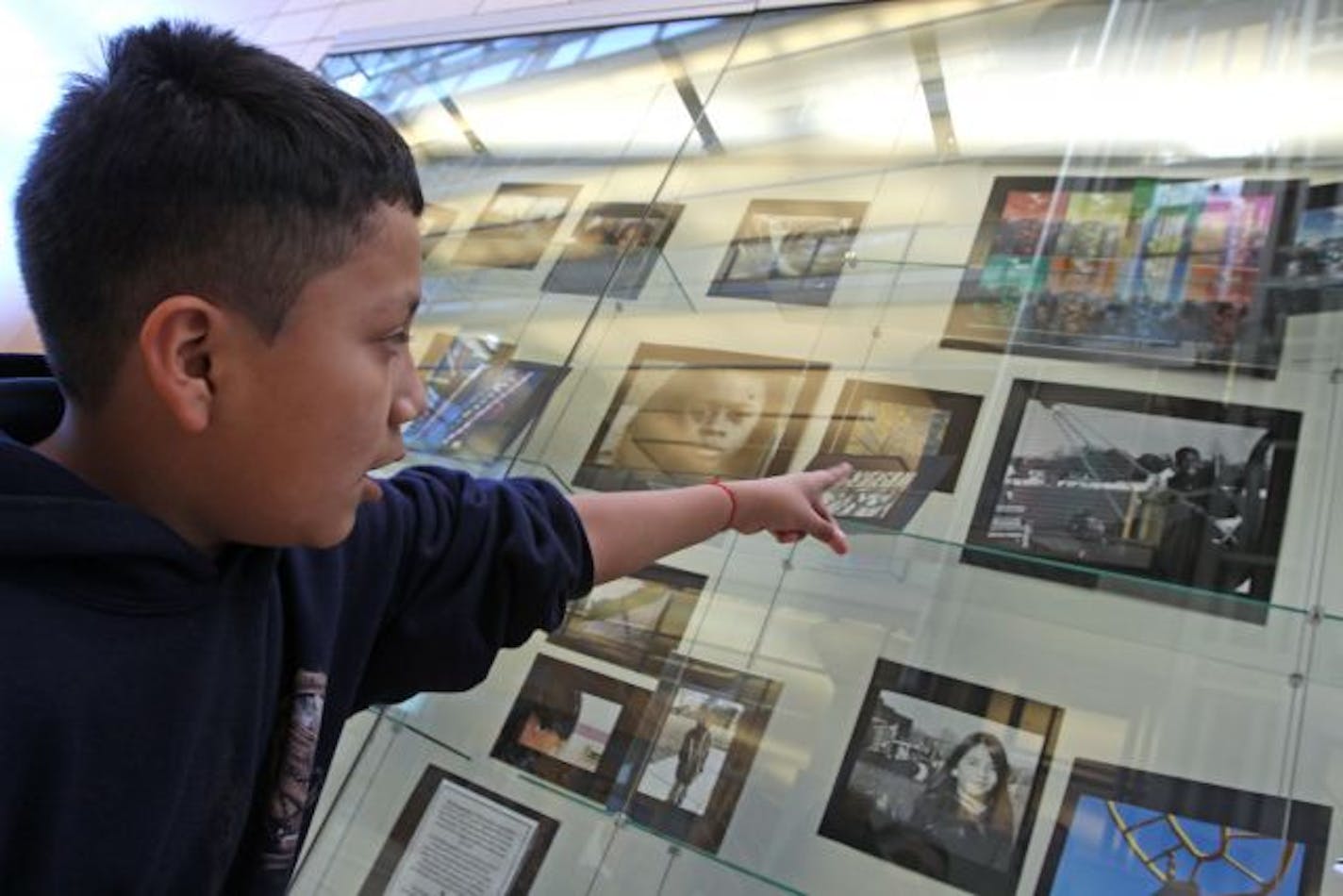 Student Luis Lopez talked about his photos as students from the Nellie Stone Johnson Community School visited their photo exhibit at the Minneapolis library. The students learned photography skills at an after-school program of the YMCA Beacons Center.