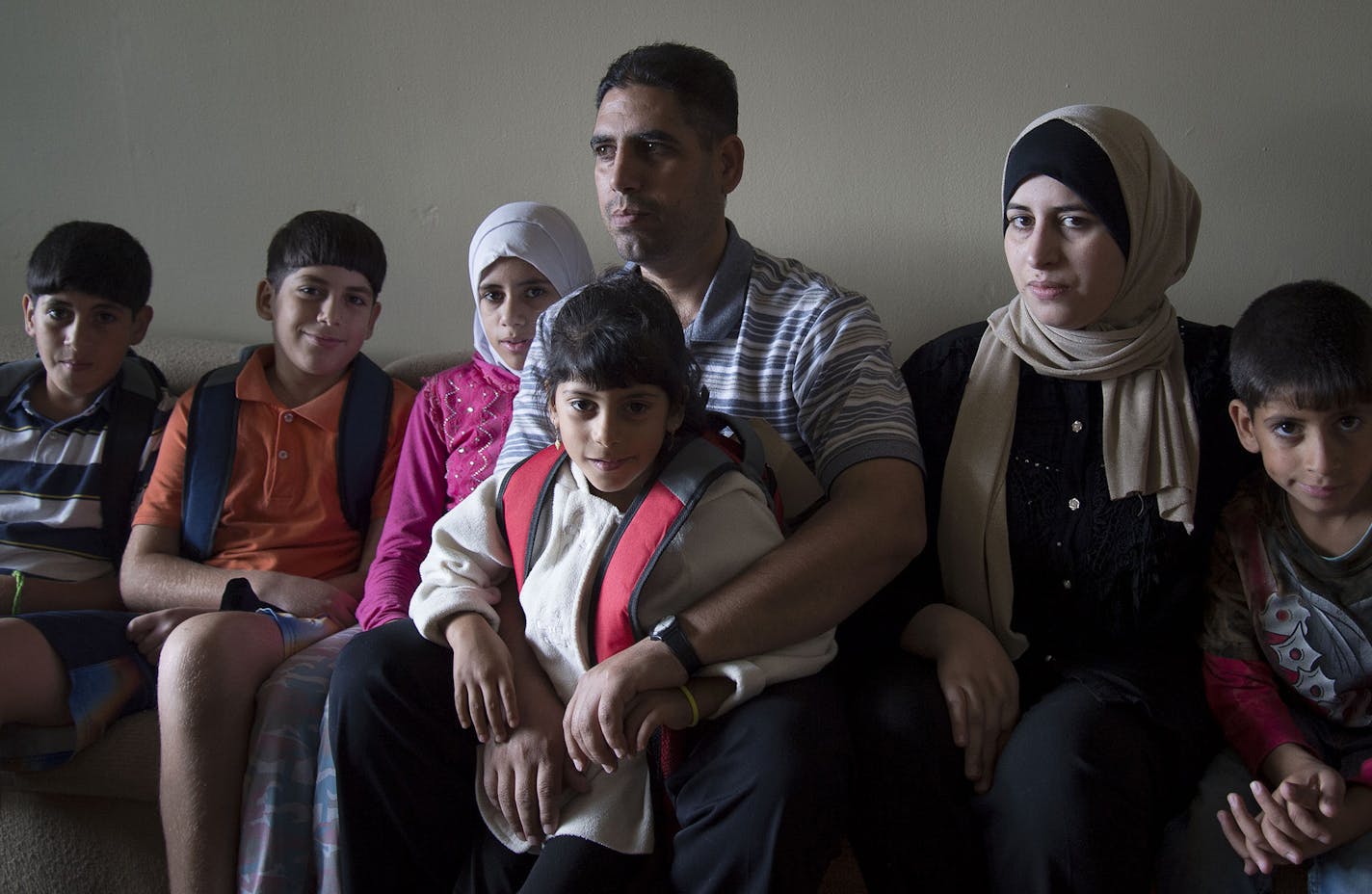 From left, Khaled Mohamad Khir Alobeid, 11, Raed Mohamad Khir Alobeid, 12, Noura Mohamad Khir Alobeid, 14, Mohamad Khir A Al Obeid, Samar Mohamad Khir Alobeid, 5, Ramia Abdulkarim Aljasem and Abdulbari Mohamad Khir Alobeid, 7, at their home in Rochester, Minn., on Friday September 11, 2015. ] RACHEL WOOLF The family of seven are refugees from Syria that came to Rochester, Minn. in April. ORG XMIT: MIN1509111417070097