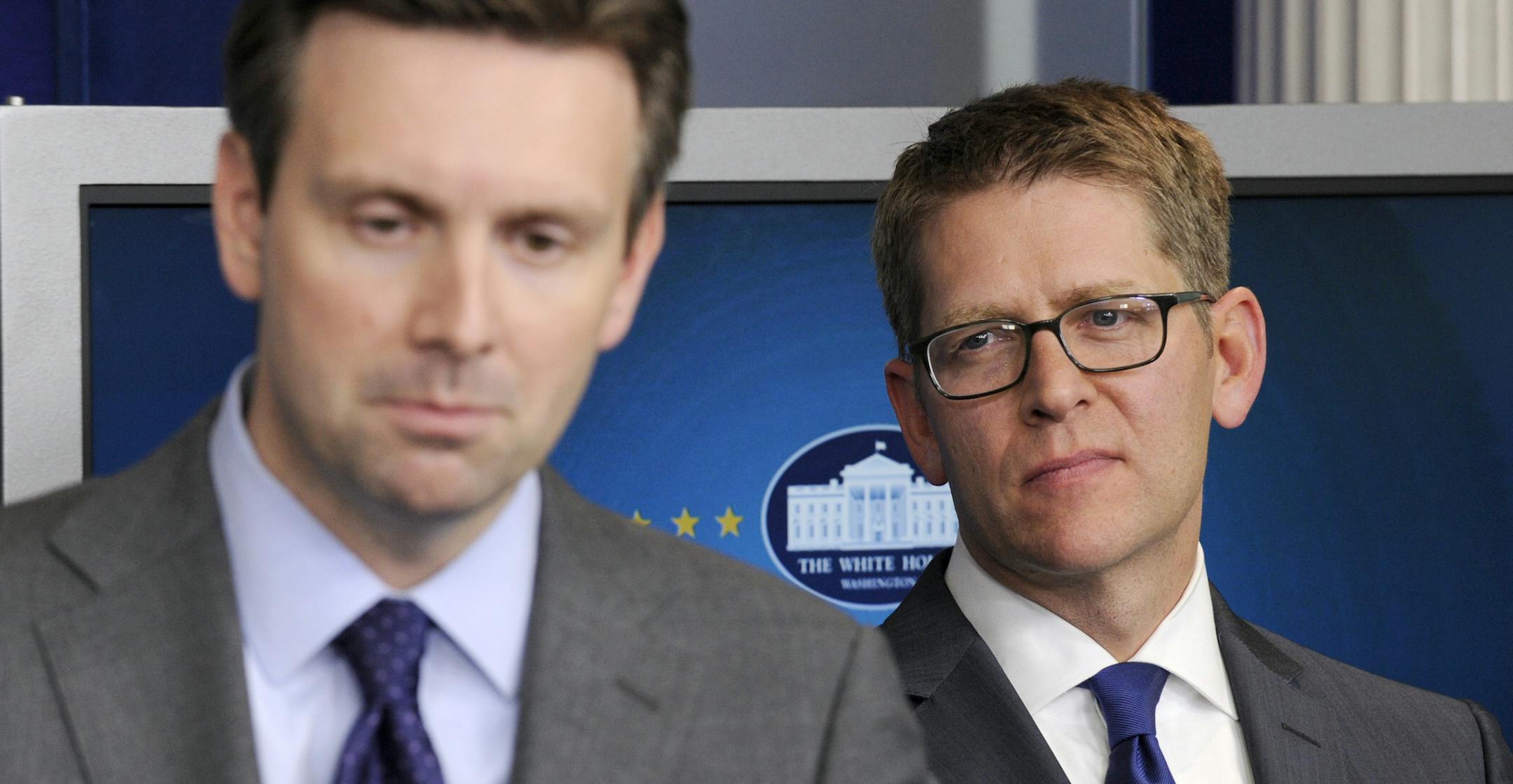 White House Press Secretary Jay Carney, right, listens as Principal Deputy Press Secretary Josh Earnest, left, answers a question during the daily briefing at the White House in Washington, Friday, May 30, 2014. President Barack Obama made a surprise visit at the briefing to announce that Carney will be stepping down and his successor will be Earnest. (AP Photo/Susan Walsh)