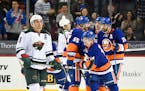 Islanders defenseman Thomas Hickey (14) celebrated his goal with teammates as Wild left winger Zach Parise (11) reacted in the third period Sunday. Th