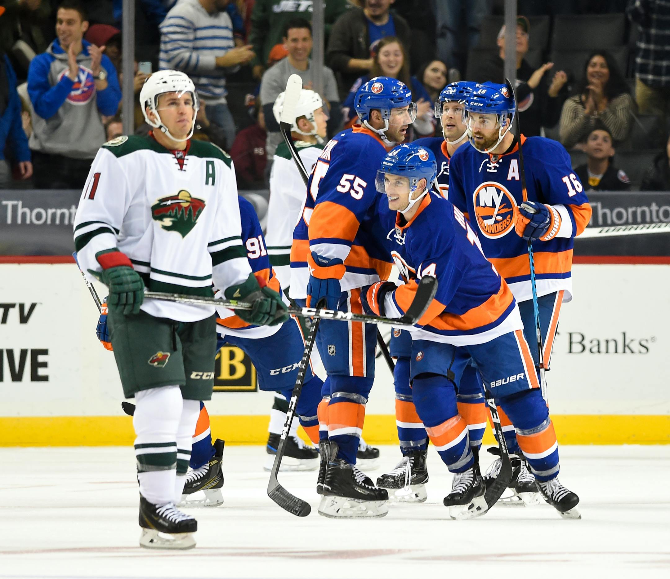 Islanders defenseman Thomas Hickey (14) celebrated his goal with teammates as Wild left winger Zach Parise (11) reacted in the third period Sunday. The Islanders won 6-3.