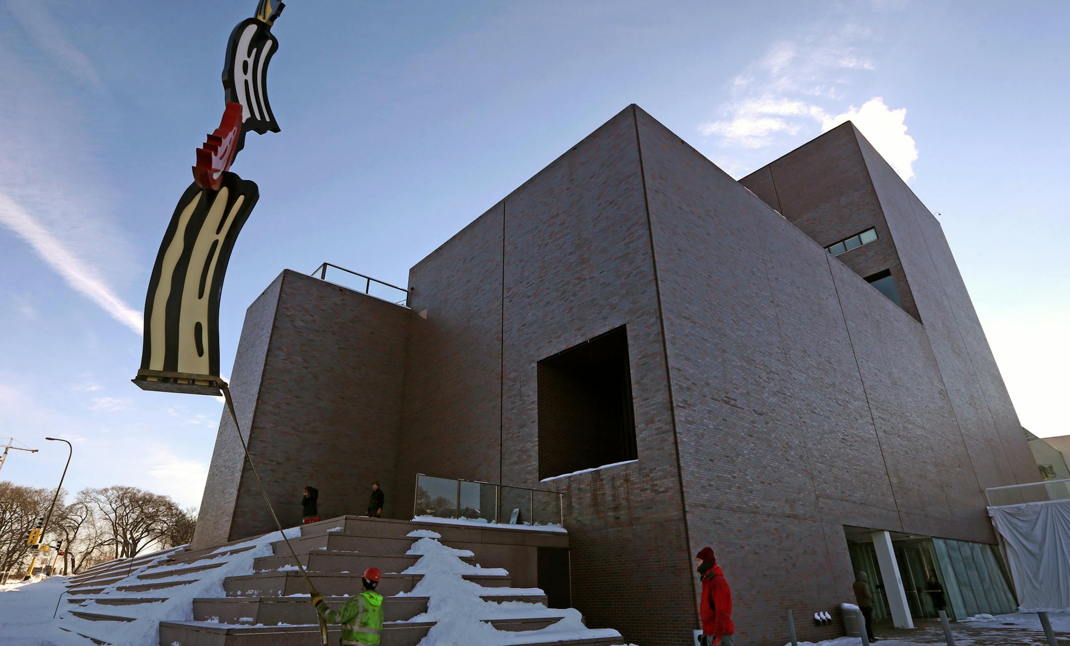 Crews from the Walker Art Center and Rocket Crane re-install Roy Lichtenstein's Salute to Painting on the Vineland Terrace on 12/12/13. The sculpture is a big colorful brush stroke by the late Roy Lichtenstein, which was given to the Walker back in the 1990s by former board members in honor of then director Martin Friedman. The sculpture has been in storage for past year while the 1971 wing of the building, designed by architect Edward Larrabee Barnes, was re-bricked. The $8 million re-bricking
