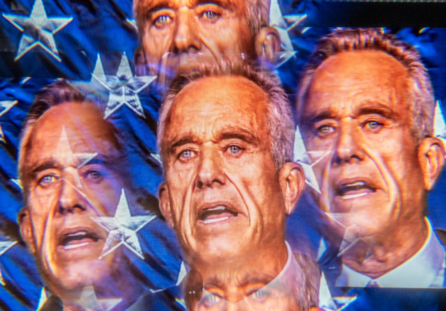 In a multiple-exposure image made from a video being played at the event site, Robert F. Kennedy Jr. campaigns in Goffstown, N.H., on June 20, 2023.