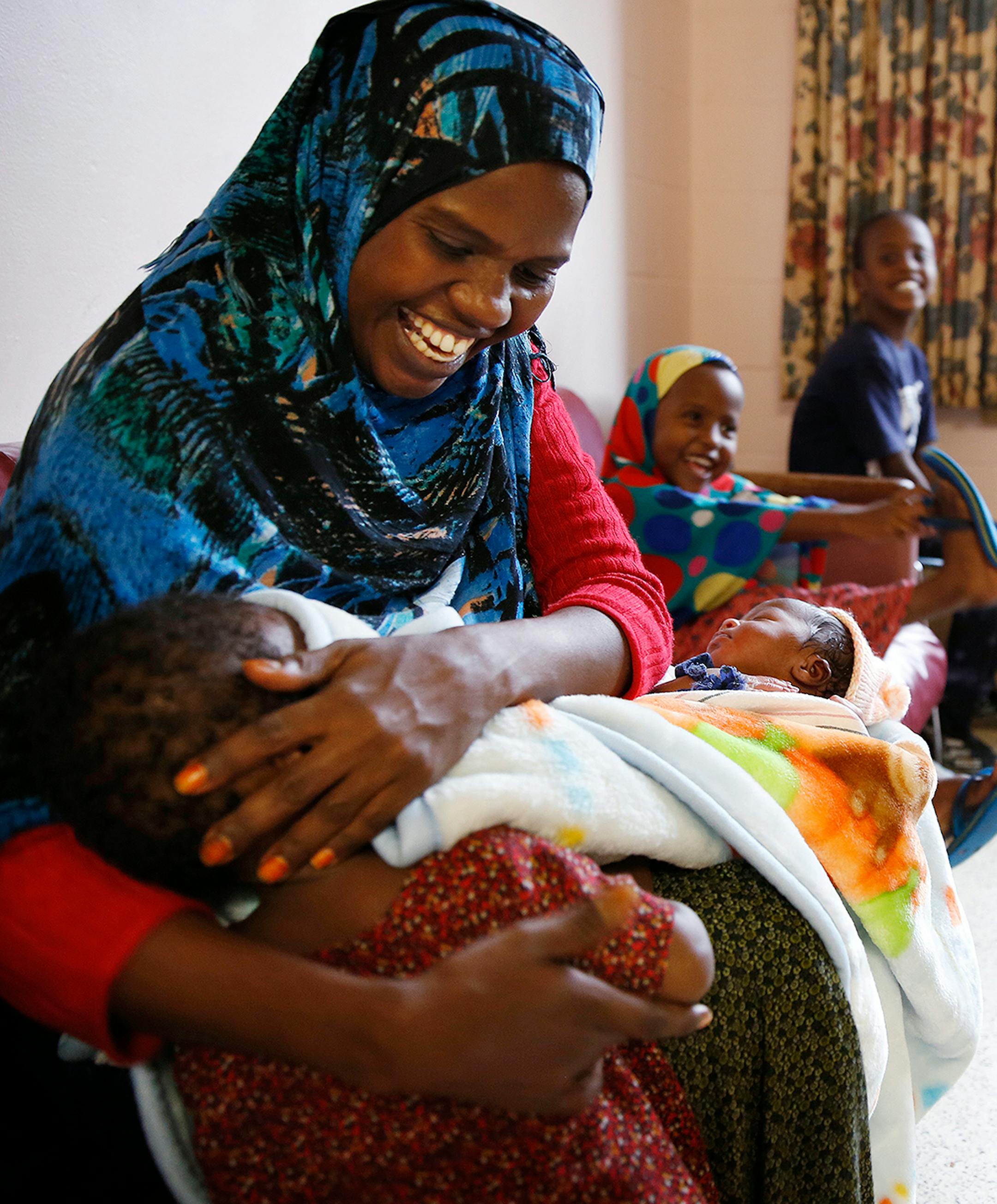 Recent Somali immigrant Mahado Mohamed plays with her one-year-old daughter Ikra Shukri while her son Shukri Shukri, 9, laughs, right, inside their apartment at Mary's Place transitional apartments in downtown Minneapolis. ] LEILA NAVIDI leila.navidi@startribune.com / BACKGROUND INFORMATION: Tuesday, October 28, 2014. Minnesota has seen a marked uptick in new Somali refugee arrivals recently. The number of Somalis arriving directly from Africa has more than tripled in four years. But community l