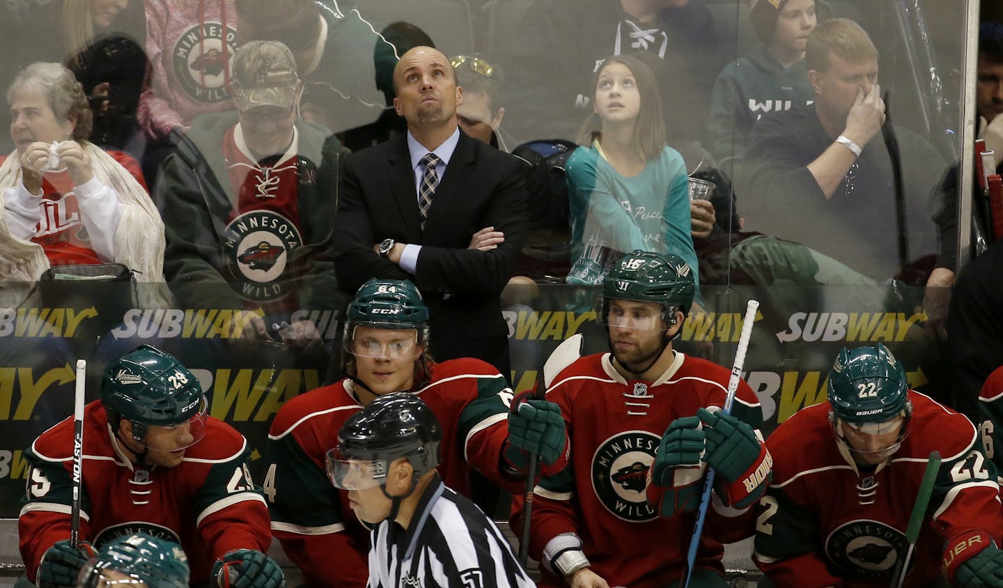 Minnesota Wild head coach Mike Yeo checks the scoreboard during the third period of an NHL hockey game against the Boston Bruins in St. Paul, Minn., Saturday, Feb. 13, 2016. The Bruins won 4-2. (AP Photo/Ann Heisenfelt)