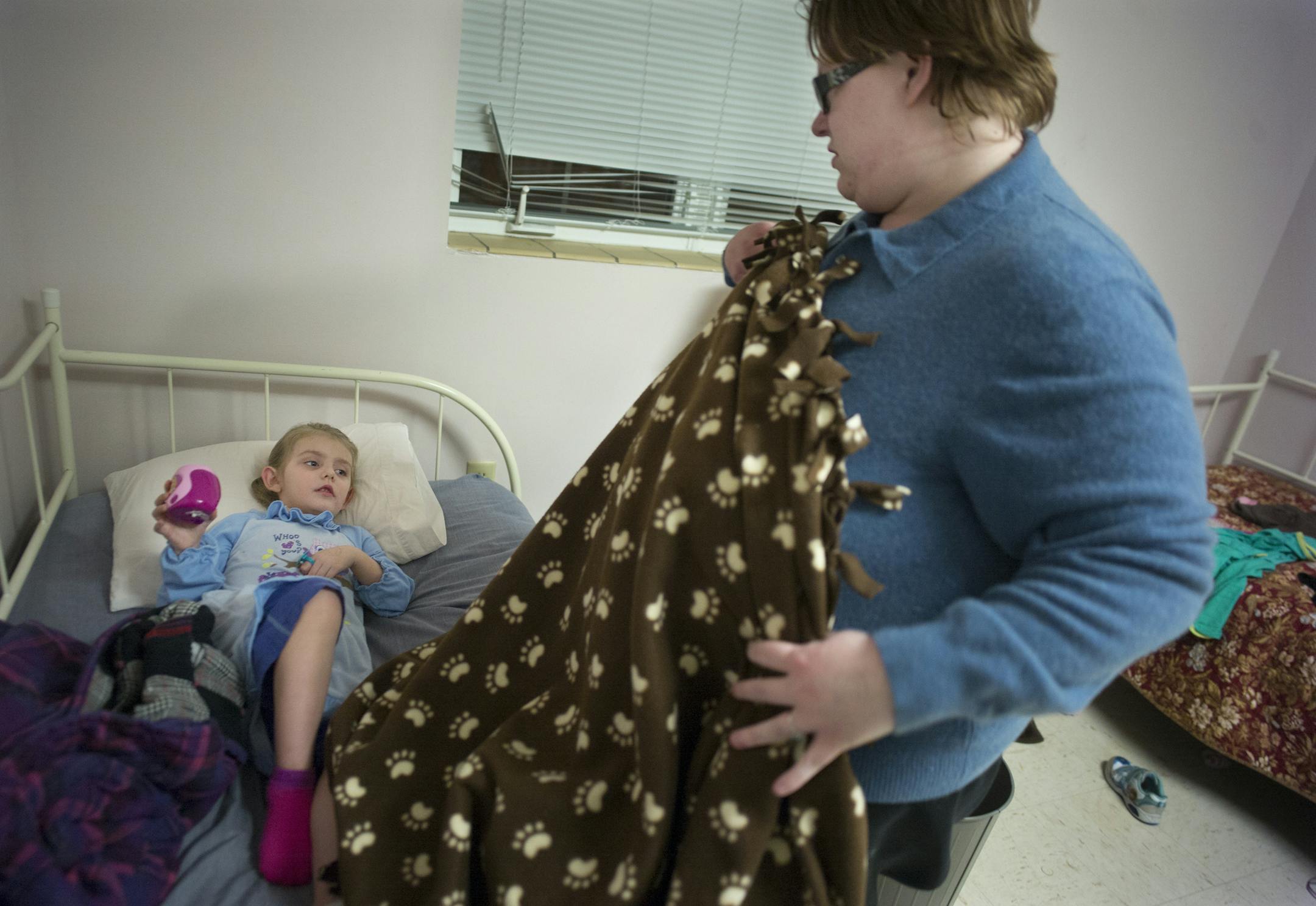 At the Dakota Woodlands shelter in Eagan, Anita Hill puts her daughter, Cora, 3.5, to bed. Her daughter who has mild autism will be starting preschool. Hill just obtained a Section 8 voucher and is looking forward to life in a more permanent setting .]Richard Tsong-Taatarii/rtsong-At taatarii@startribune.com