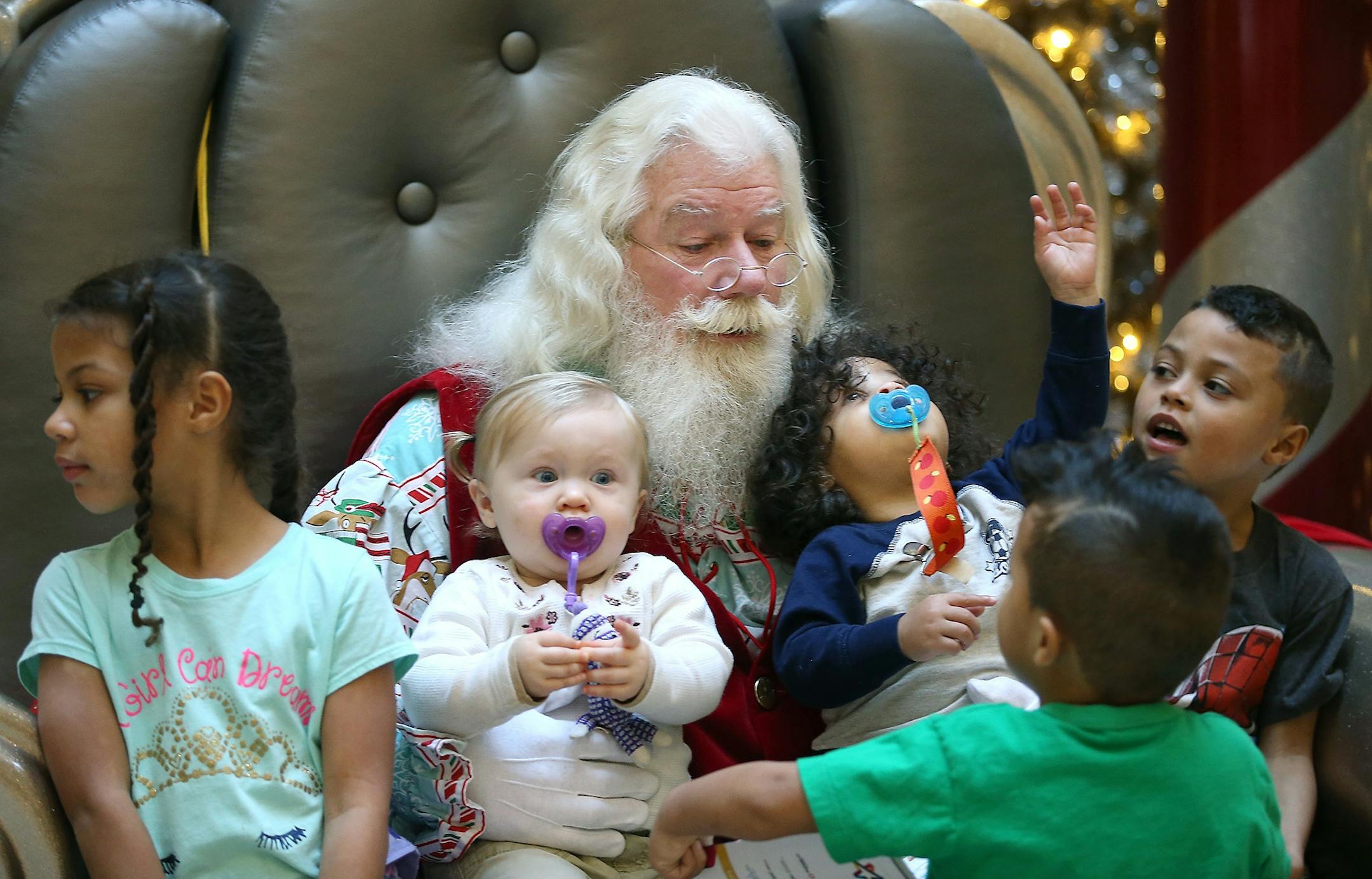 "Santa" tried to calm the chaos around him as Daniella Halstead, 6, from left, Riley Richey, 1, Derek Halstead, 4, Dominic Halstead, 1, and Dante Halstead, 6, met with him for gift requests and for a photo at the North Pole at the Mall of America, Thursday, December 3, 2015 in Bloomington, MN.