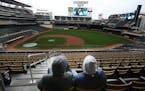 Twins fans Greyson Altermose, left, and his father, Trey Altermose, watched their team open the season against the Detroit Tigers on the big screen at