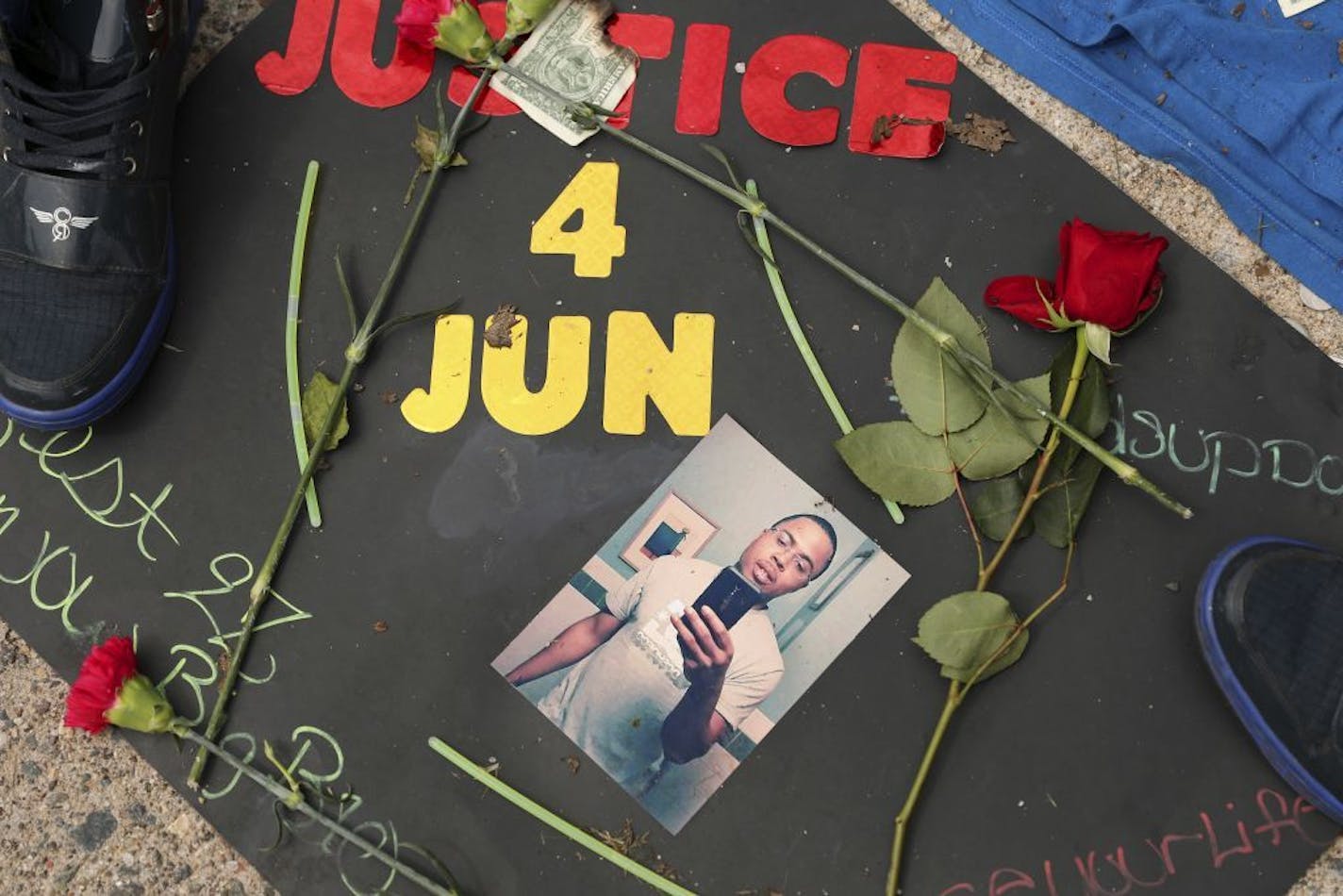 A memorial is set up in the alley where Thurman Blevins was killed by a Minneapolis police officer earlier in the week, in Minneapolis, Monday, June 25, 2018. Some community members are disputing authorities' account that the black man had a gun before he was fatally shot by Minneapolis police, but a man who heard the shooting and saw the immediate aftermath said he saw a firearm near Thurman Blevins Jr.'s hand. The differing narratives prompted community leaders and officials to call for the sw