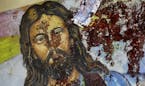 A blood-spattered poster of Jesus Christ is seen inside the the Coptic Christian Saints Church in the Mediterranean port city of Alexandria, Egypt Sat