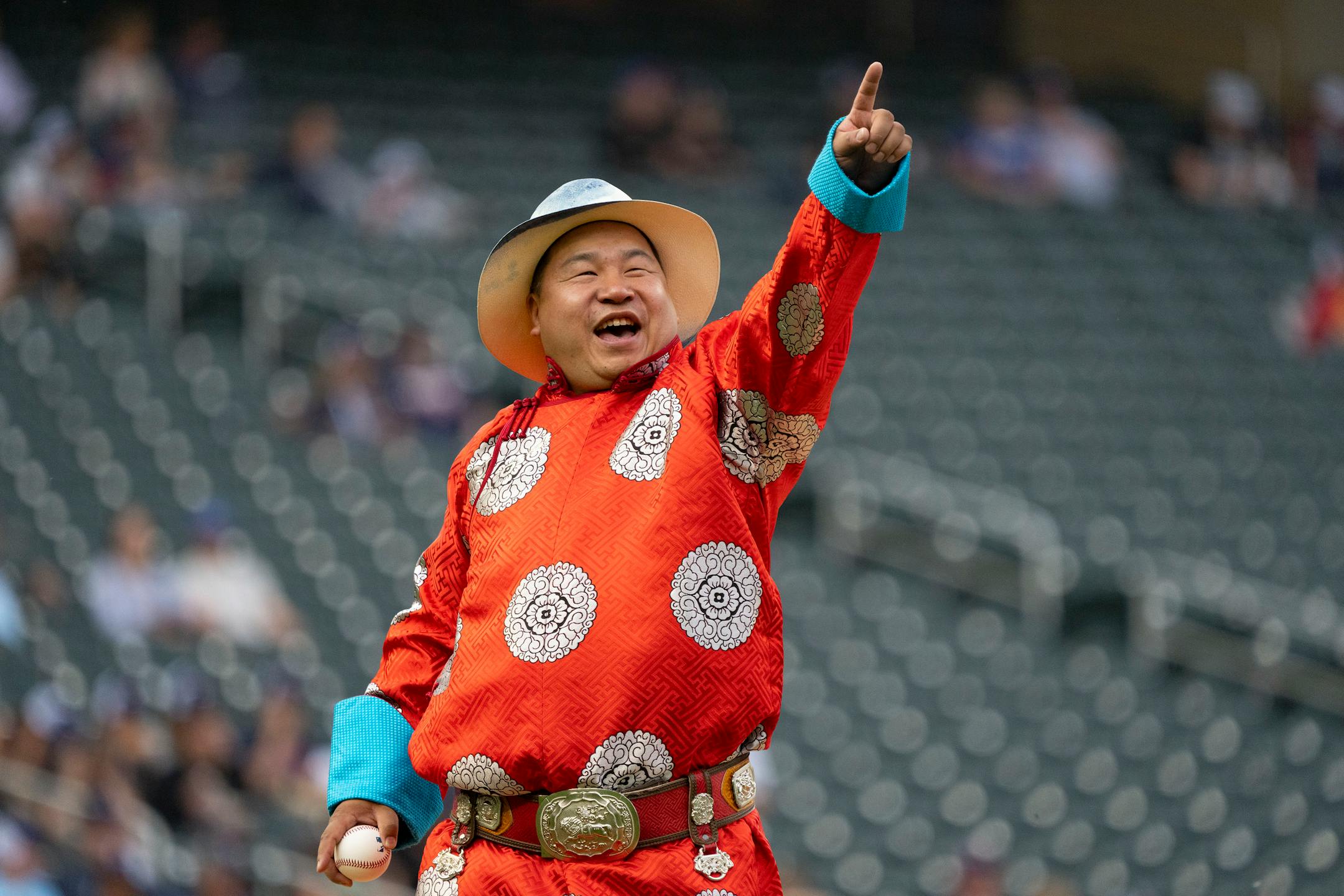 Chef Enkhbileg "Billy" Tserenbat, owner of Billy's Sushi, points to the crowd before throwing out the ceremonial first pitch.