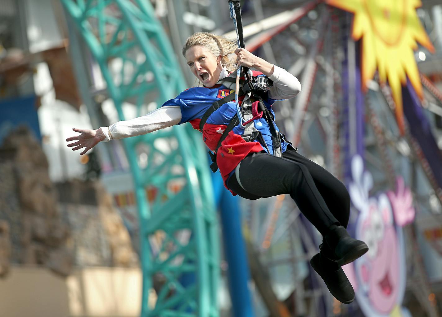 Dressed as a super hero, Hilltop Elementary School's Sue Vallafskey swung high above her students on the Mall of America's Zip Line, Thursday, November 13, 2014 in Bloomington, MN. Vallafskey joined other school principals and teachers to gain awareness for "Give to the Max" day, the annual giving extravaganza that raised $17 million in 24 hours last year. ] (ELIZABETH FLORES/STAR TRIBUNE) ELIZABETH FLORES &#x2022; eflores@startribune.com