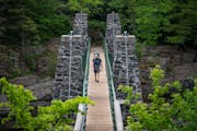 A man and his child crossed the swinging bridge at Jay Cooke State Park in Carlton, Minn.