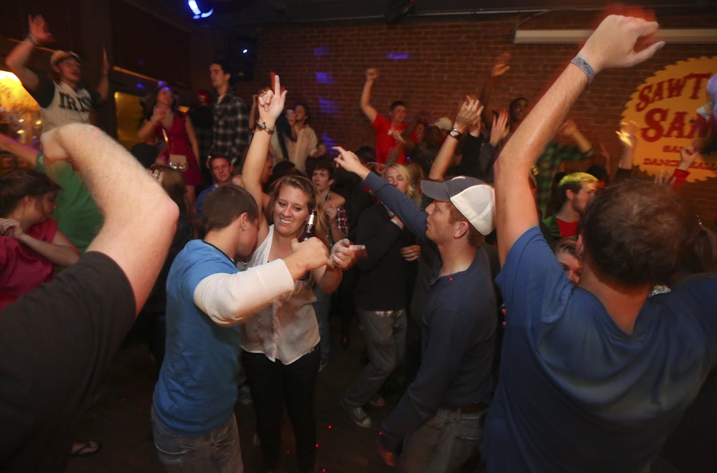 Patrons threw their hands and their drinks in the air as they dance after last call in Sawtooth Sam's Saloon in downtown La Crosse Wis., Saturday September 22, 2012.