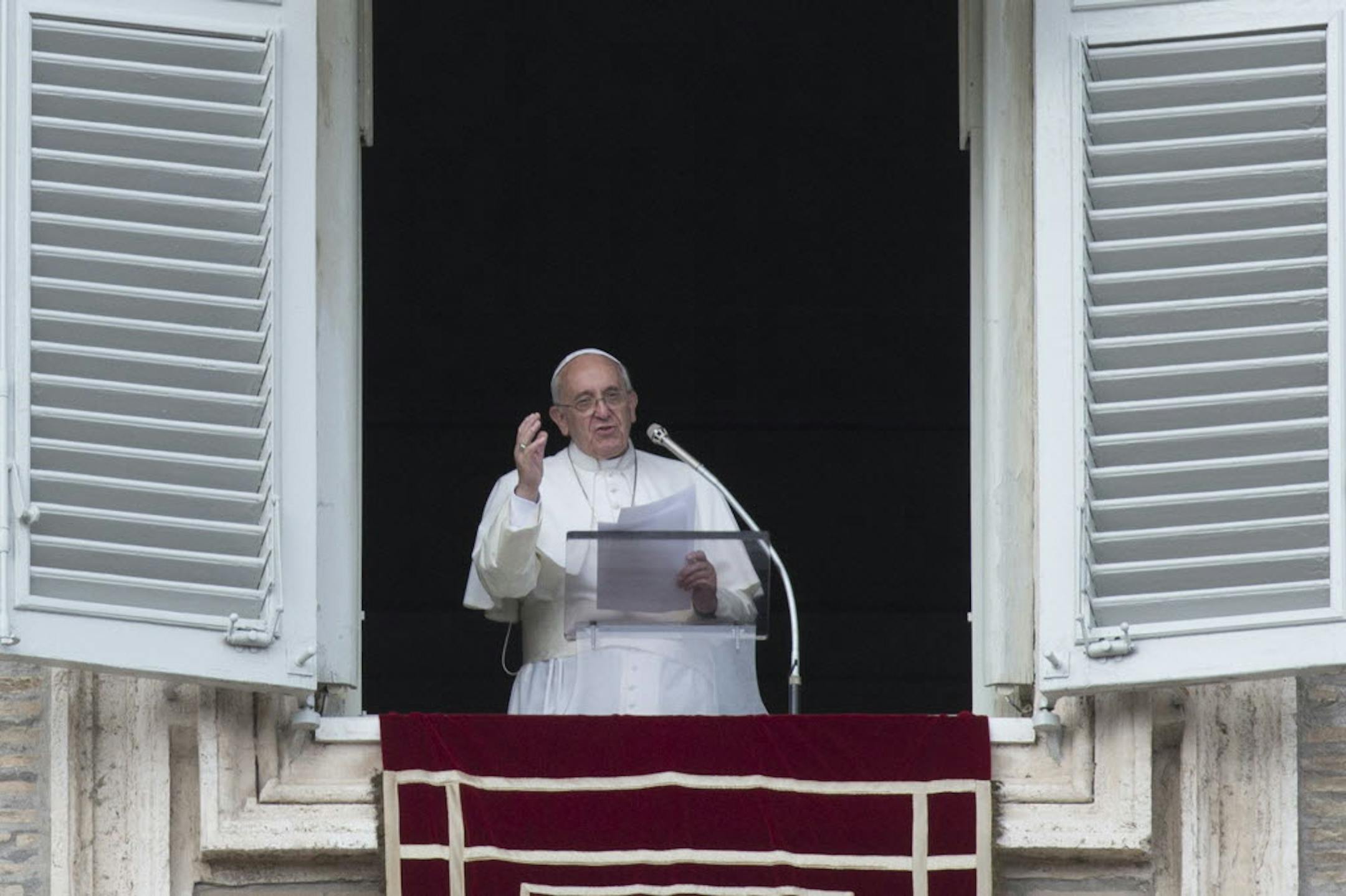 Pope Francis delivers his blessing during the Angelus noon prayer he celebrated from the window of his studio overlooking St. Peter's Square, at the Vatican, Sunday.