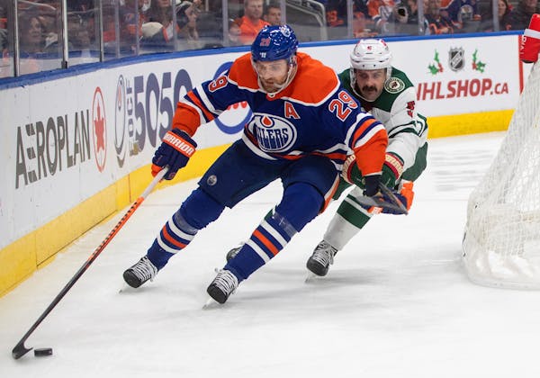 The Wild's Jacob Middleton and Edmonton's Leon Draisaitl battle for the puck during the second period Friday in Edmonton