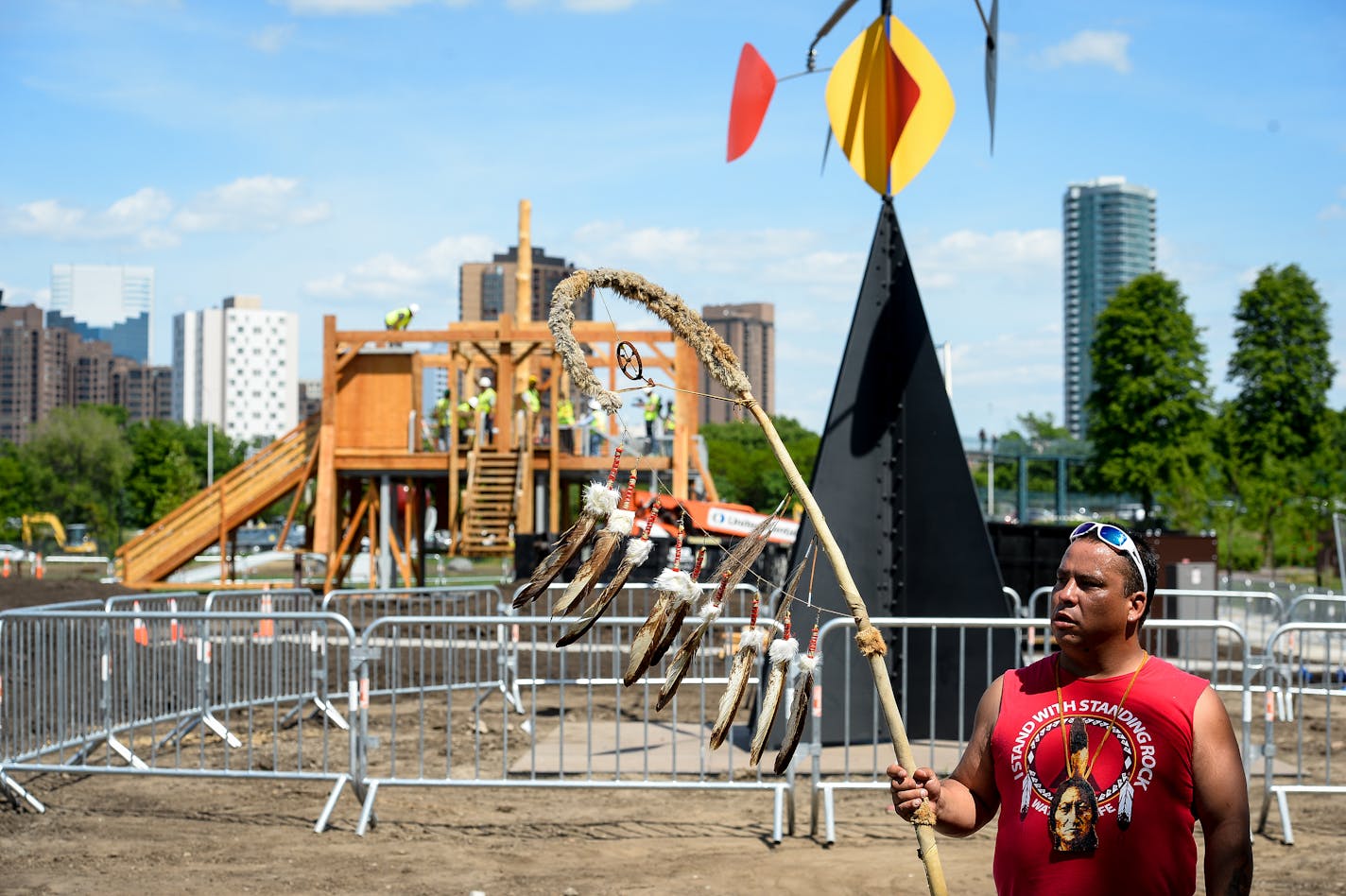 Tommy Tiokasin, with the Standing Rock Sioux Nation, held a staff from his tribal community as the "Scaffold" sculpture was dismantled behind him. Tiokasin says he is related to two of the men hung in the Dakota 38 hangings. ] AARON LAVINSKY � aaron.lavinsky@startribune.com Demolishment of the "Scaffold" sculpture began Friday, June 2, 2017 at the Minneapolis, Sculpture Garden in Minneapolis, Minn.